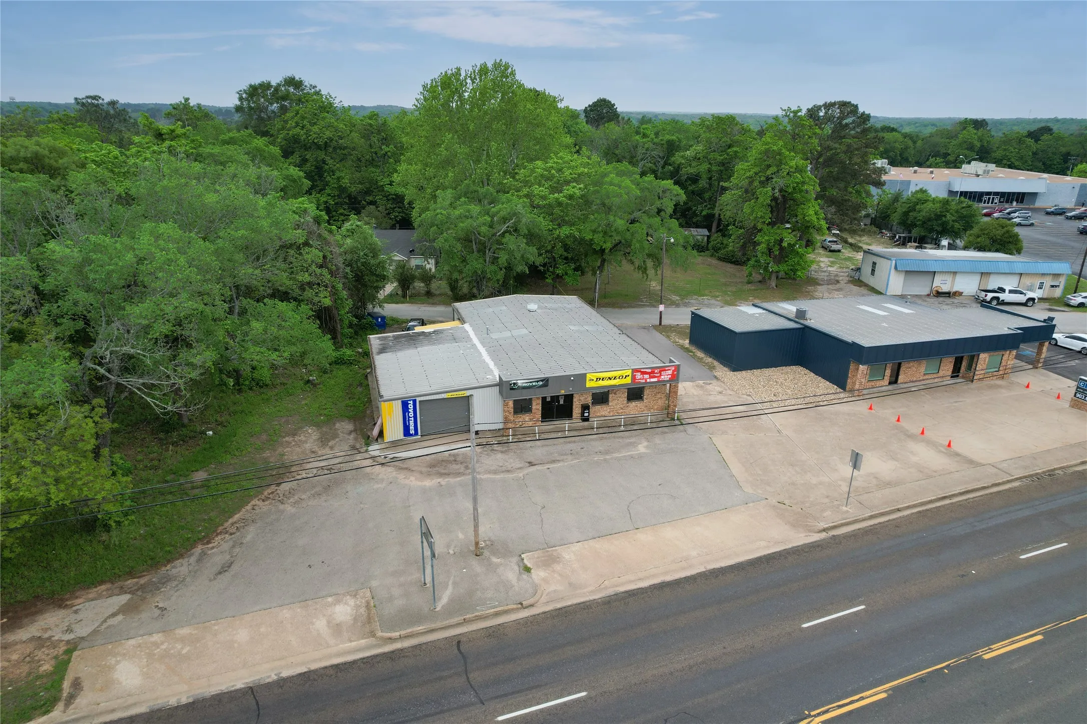 Commercial property featuring two distinct structures with ample paved lot space