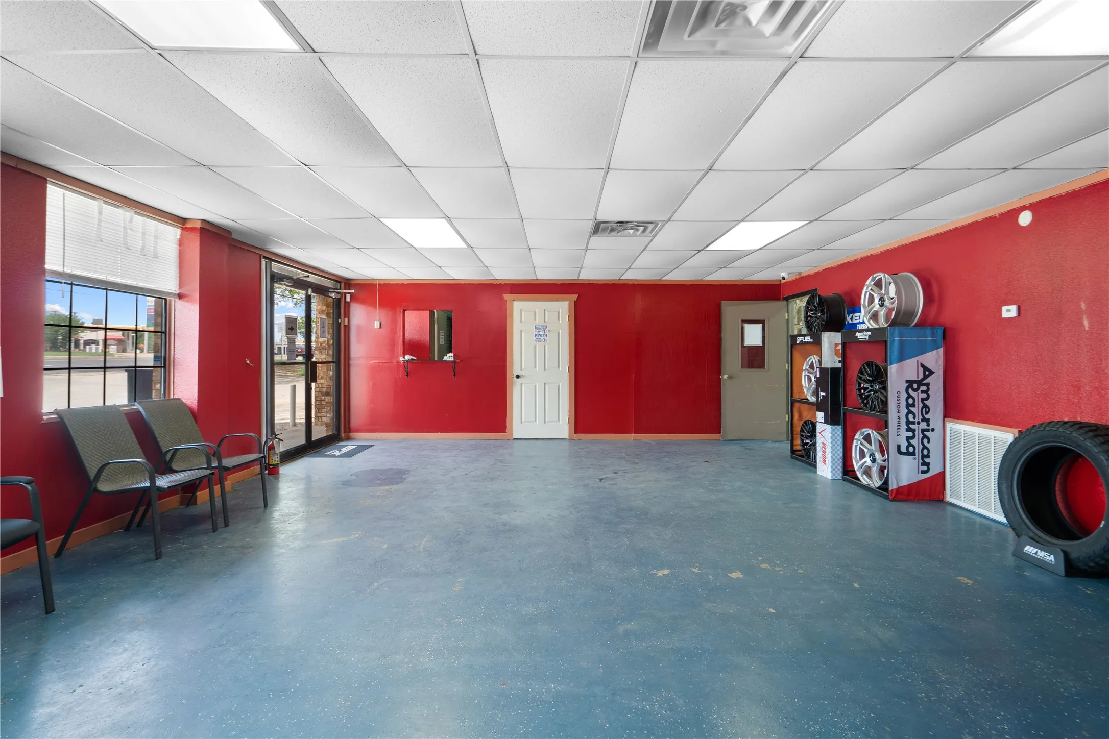 Spacious interior featuring a commercial-grade dropped ceiling with integrated lighting, durable flooring, and large storefront windows