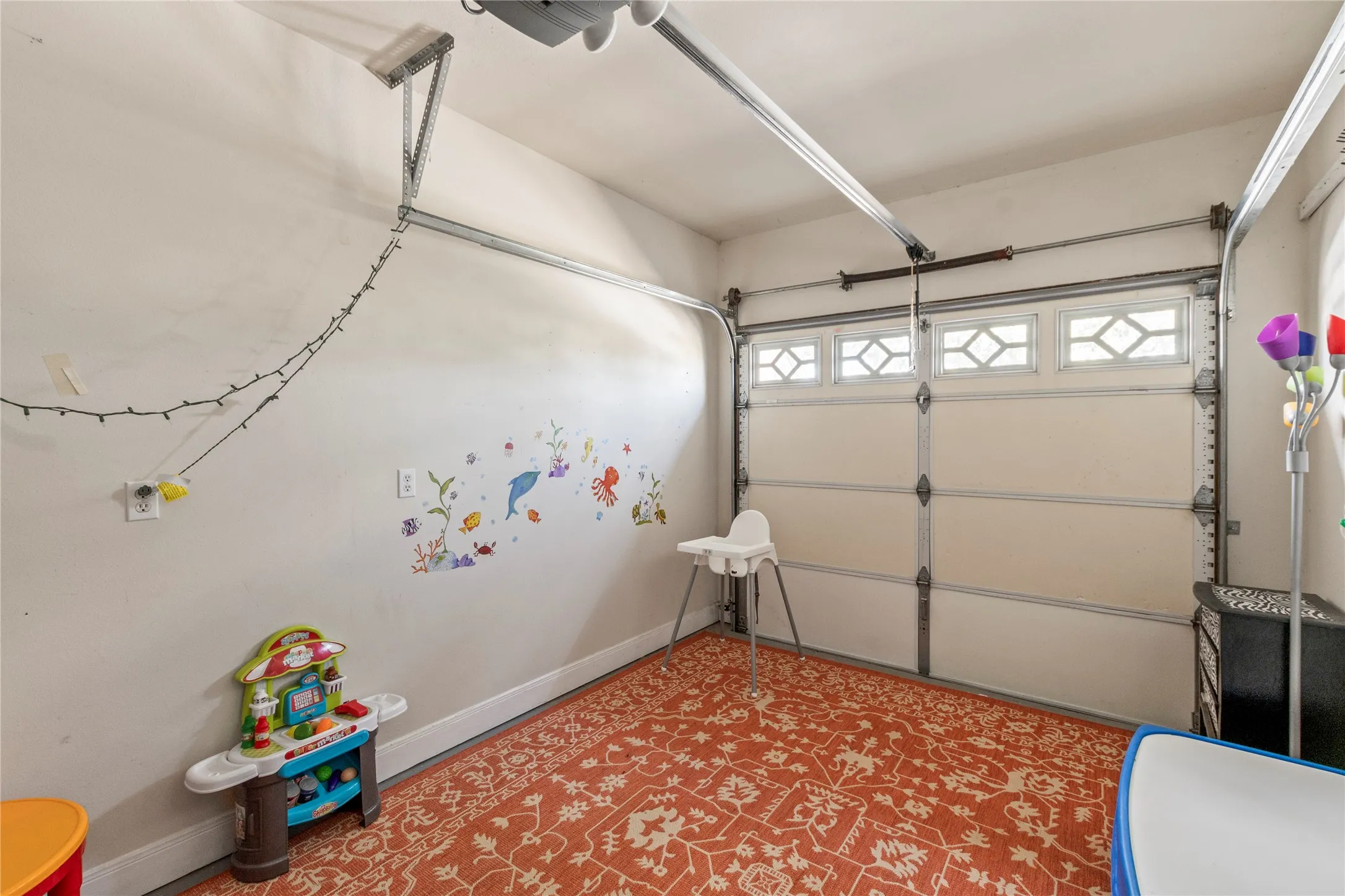 Air conditioned third car or golf cart garage currently used as playroom.