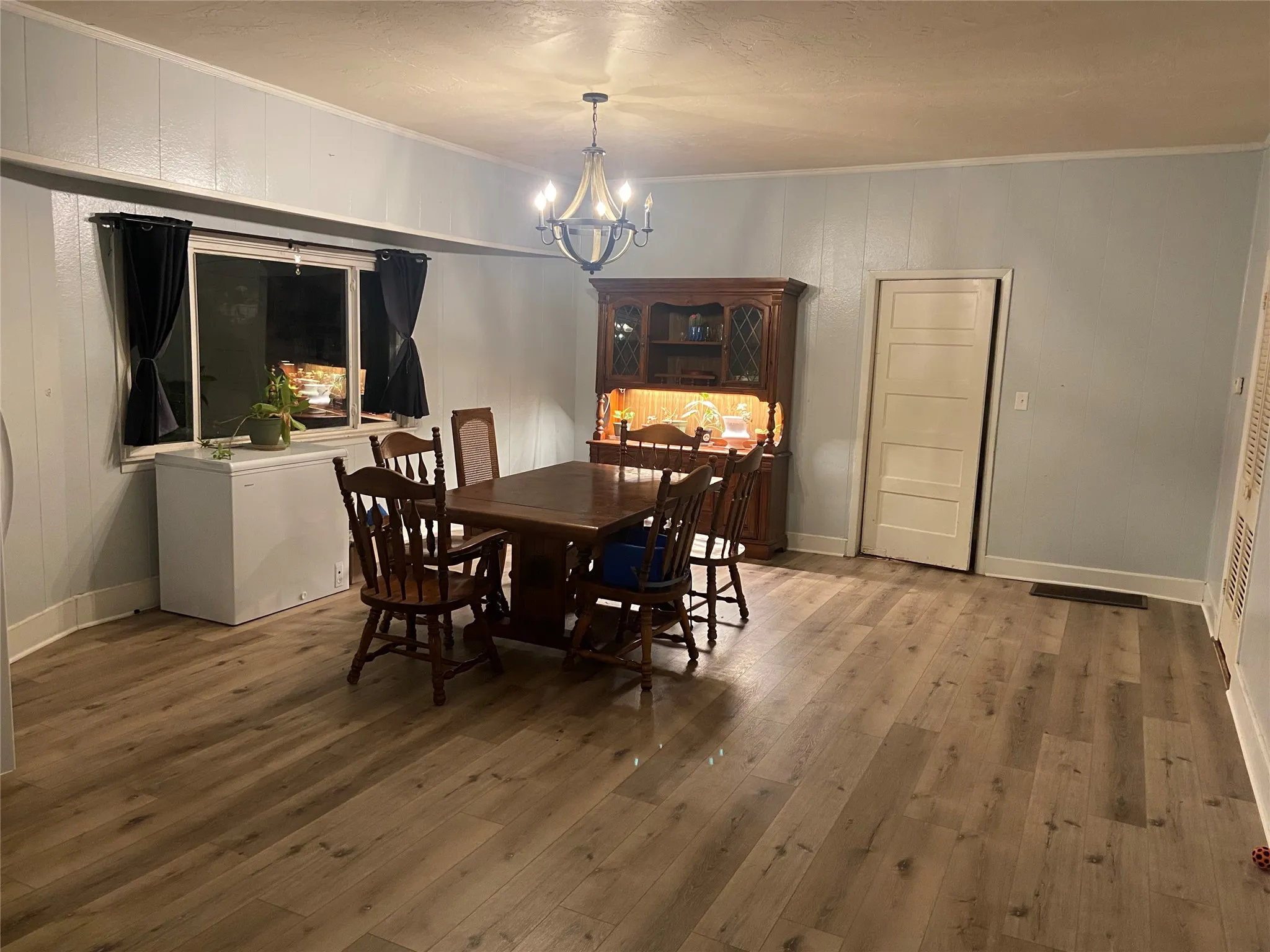 Dining space featuring wood-finish flooring and paneling walls