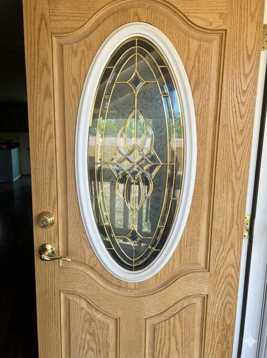 Entry door with an oval decorative glass insert, wood-grain finish, and brass-tone hardware
