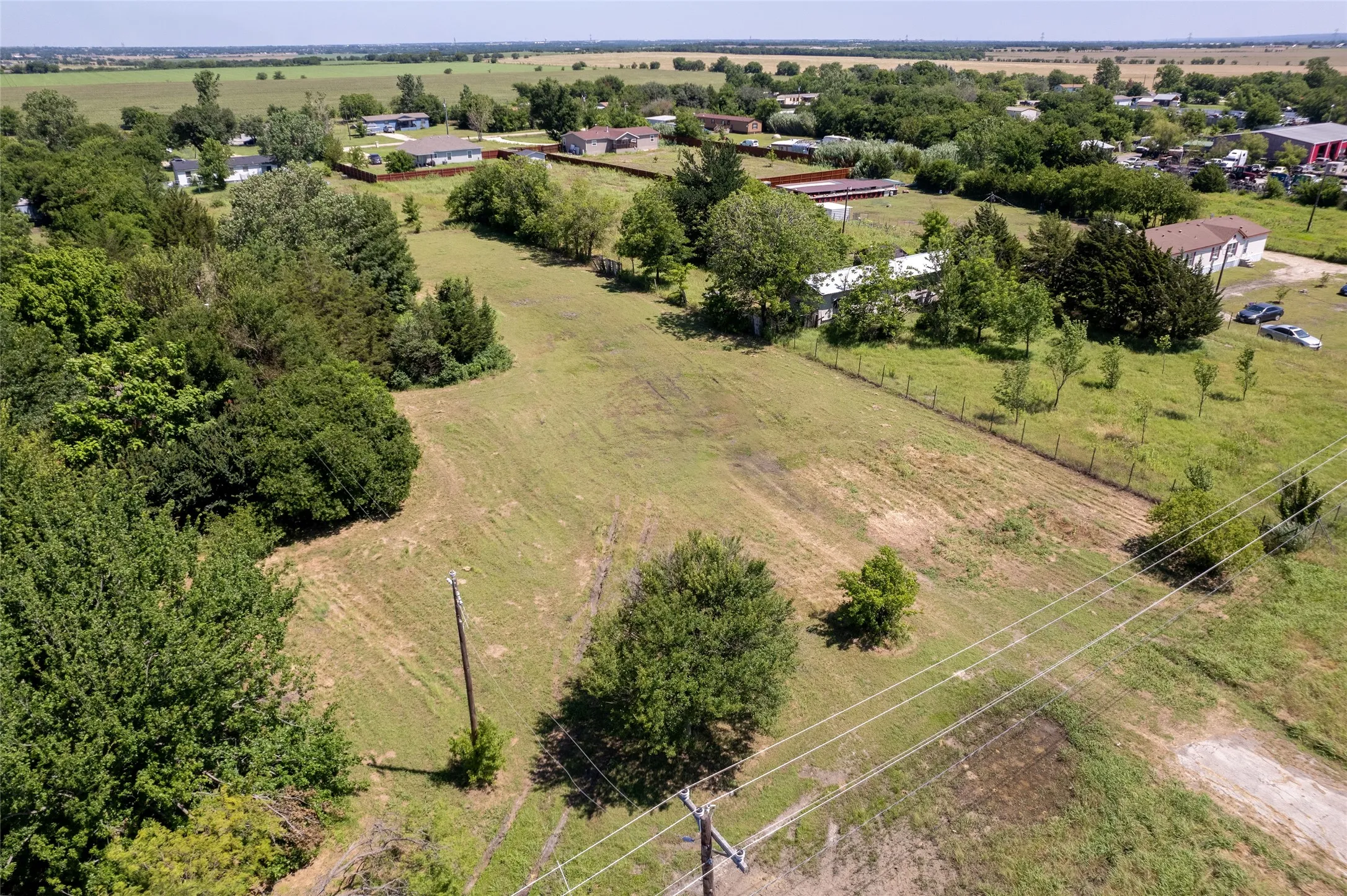 Expansive undeveloped land parcel featuring a mix of cleared fields and mature tree lines
