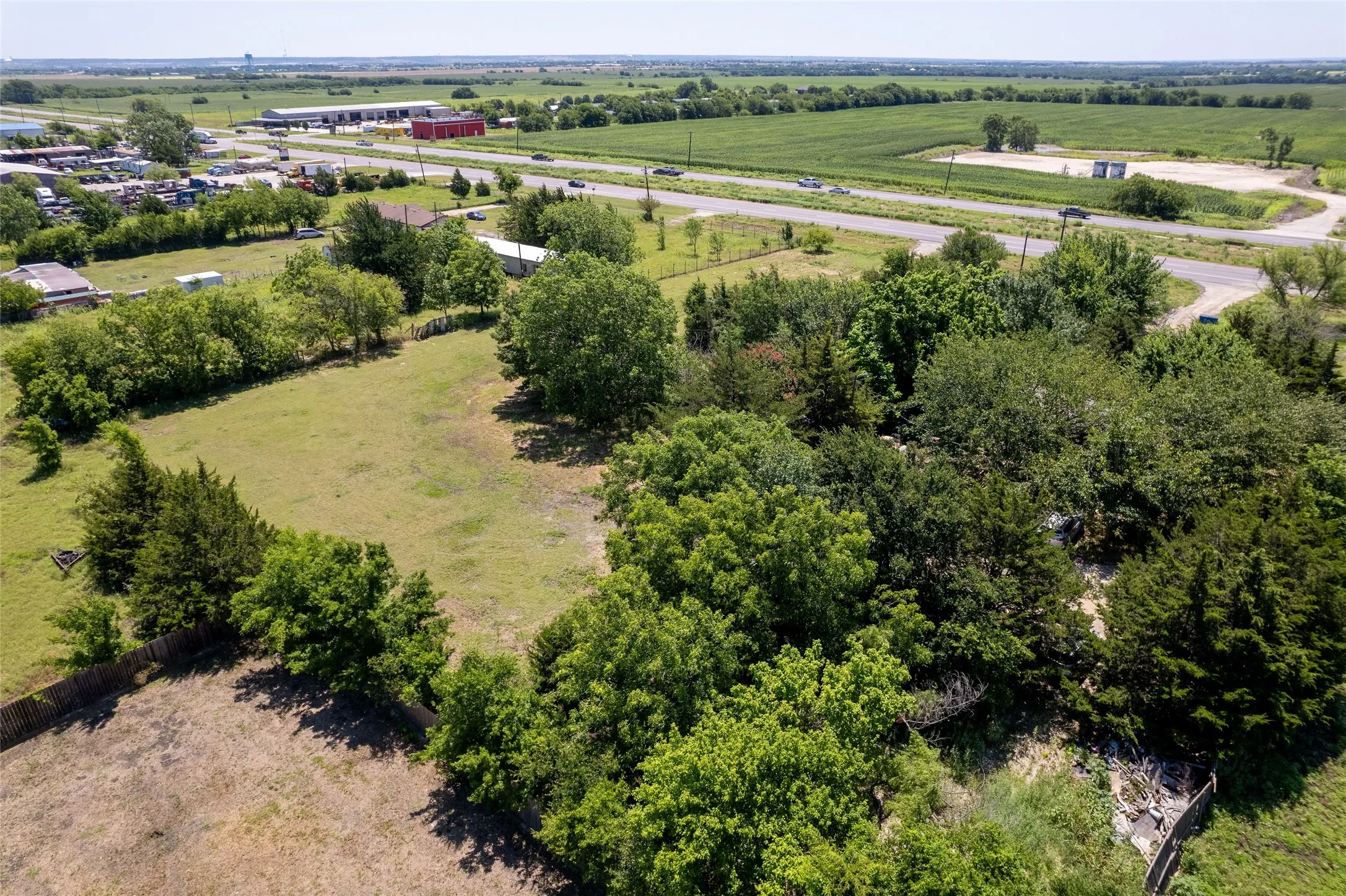 Expansive undeveloped land parcel featuring mature trees and open grassy areas