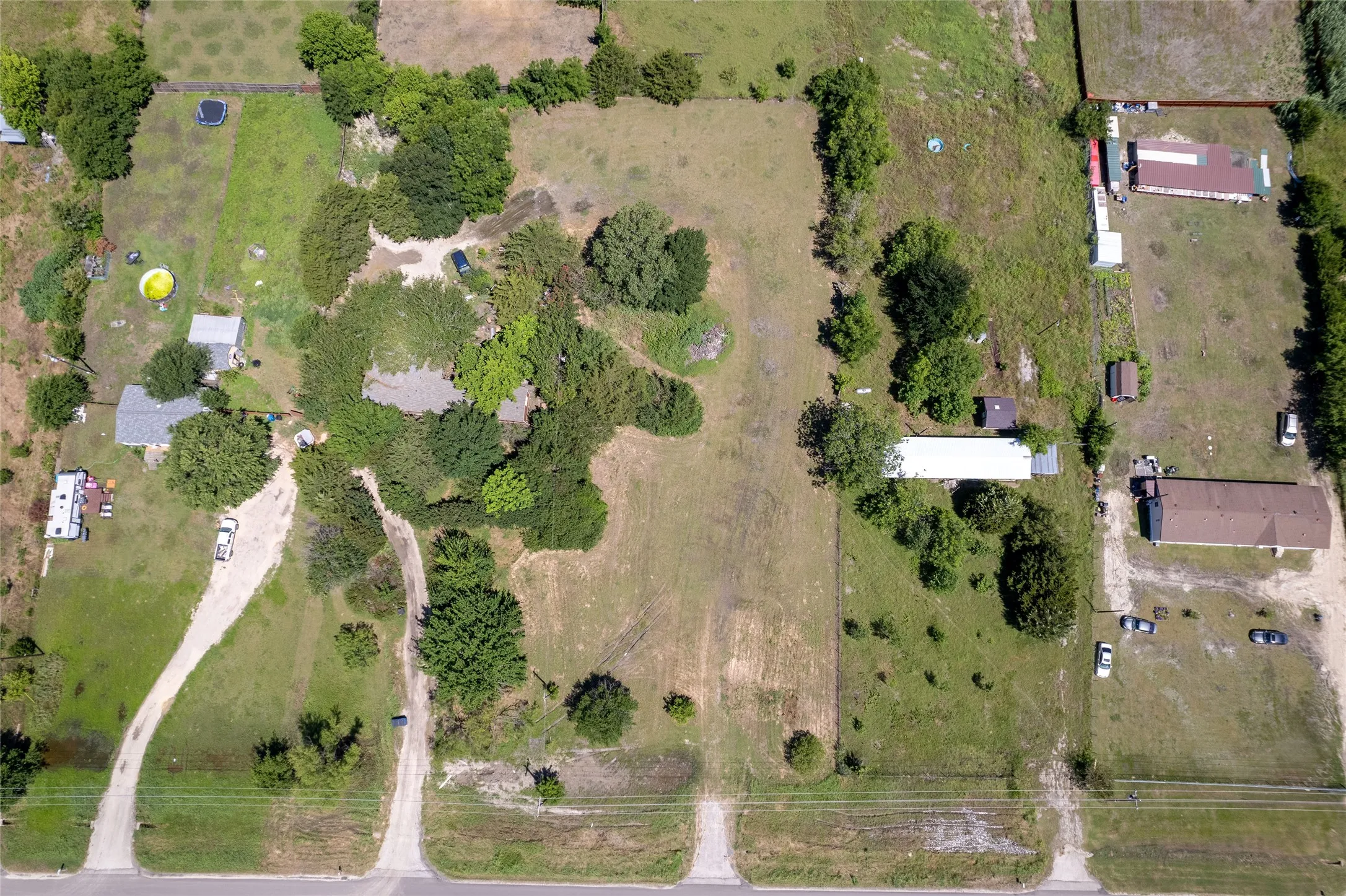 Expansive lot featuring a mix of cleared land and mature trees, with direct road frontage