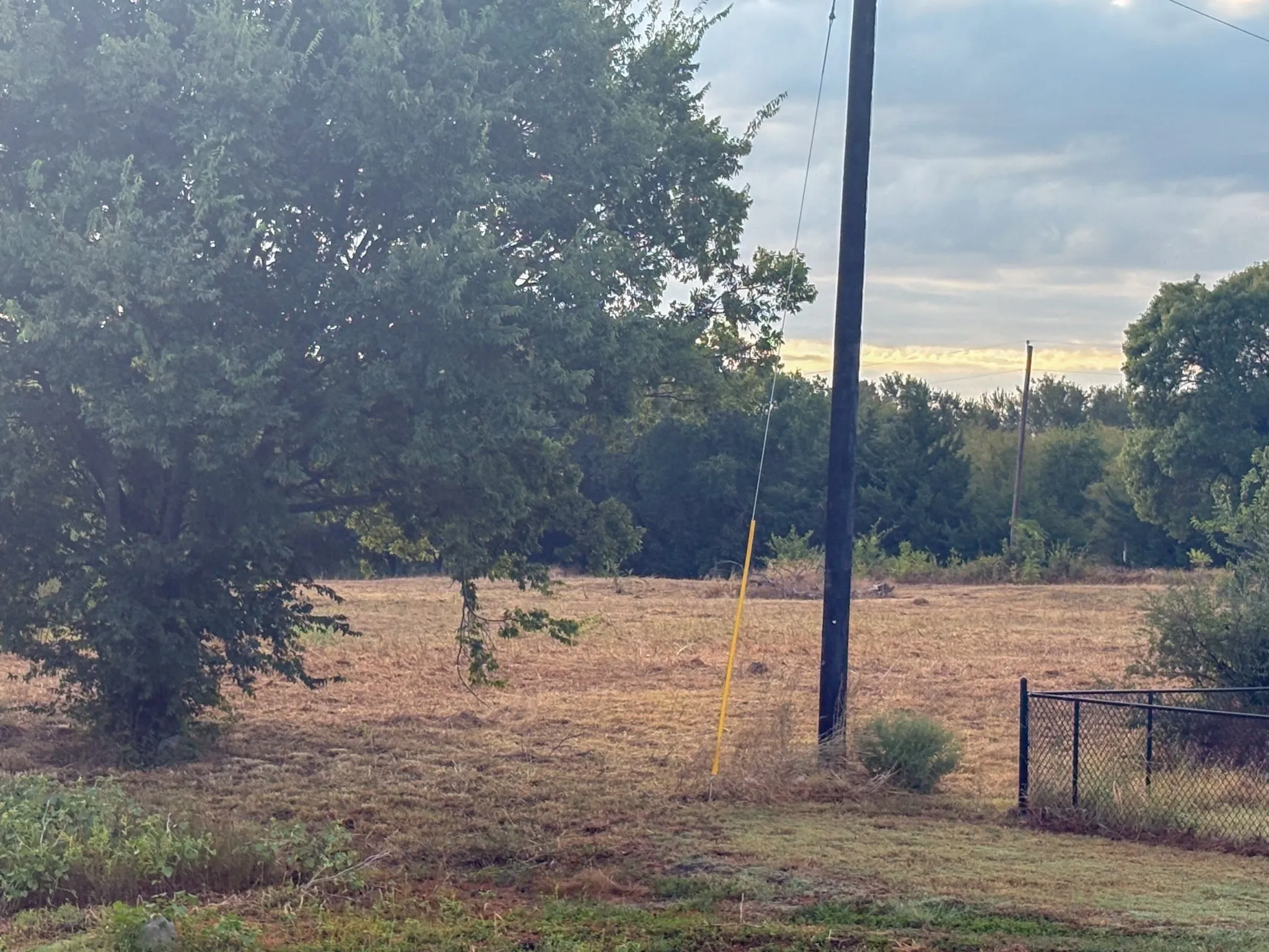 Expansive property featuring a large pond with natural banks, mature trees along the shoreline, and varied terrain
