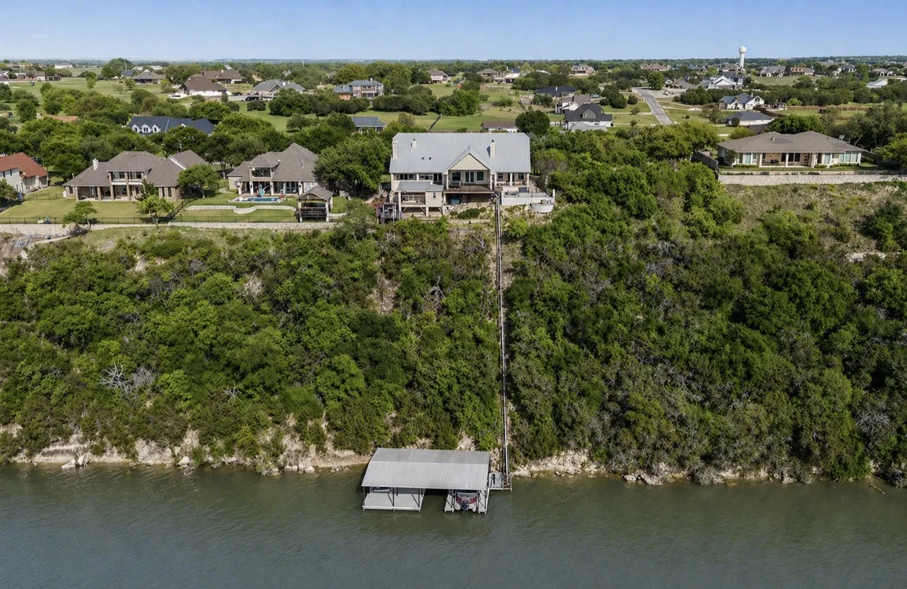 Soaring above the incredible Brazos River bend, this aerial view emphasizes the home’s elevated setting, private tram, and dock, all situated on 1.16 acres