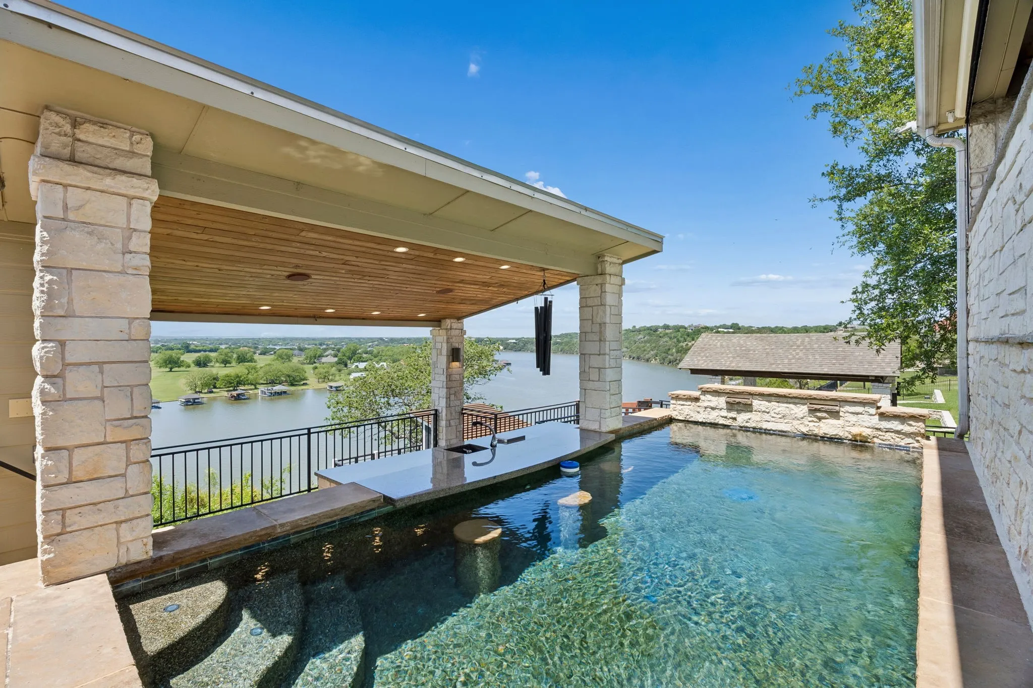 Pool with swim-up bar is on the second-tier deck. An air-conditioned powder bath is conveniently located just below, adjacent to the counter that services the swim-up bar.