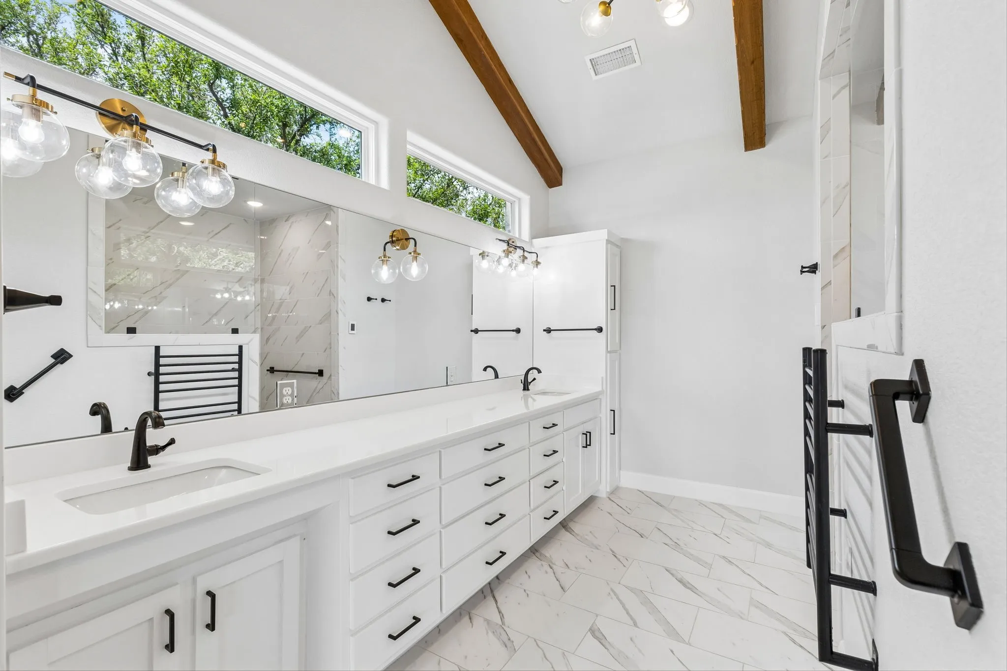 Primary bedroom with heated towel rack, heated floors, matte black finishes and bidet toilet with oversized shower amd extra long double vanities. Wood beamed ceilings-no cost was spared on this stunning remodel.