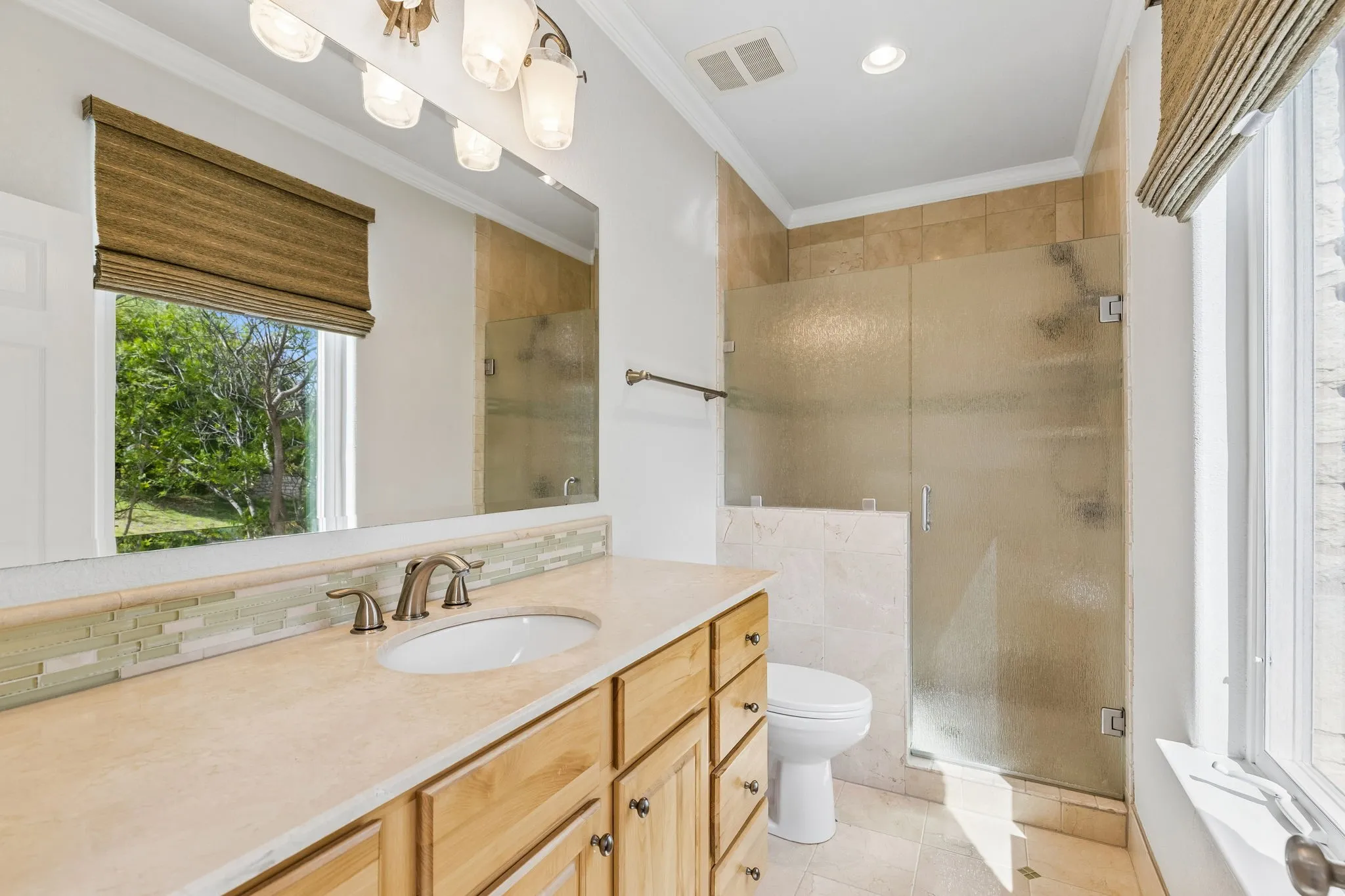 En-suite bath Generous walk-in shower offers plenty of space, while the window fills the bath with beautiful natural light.
Warm wood cabinetry (oak-toned) pairs effortlessly with the soft neutral finishes for a light, cohesive feel.