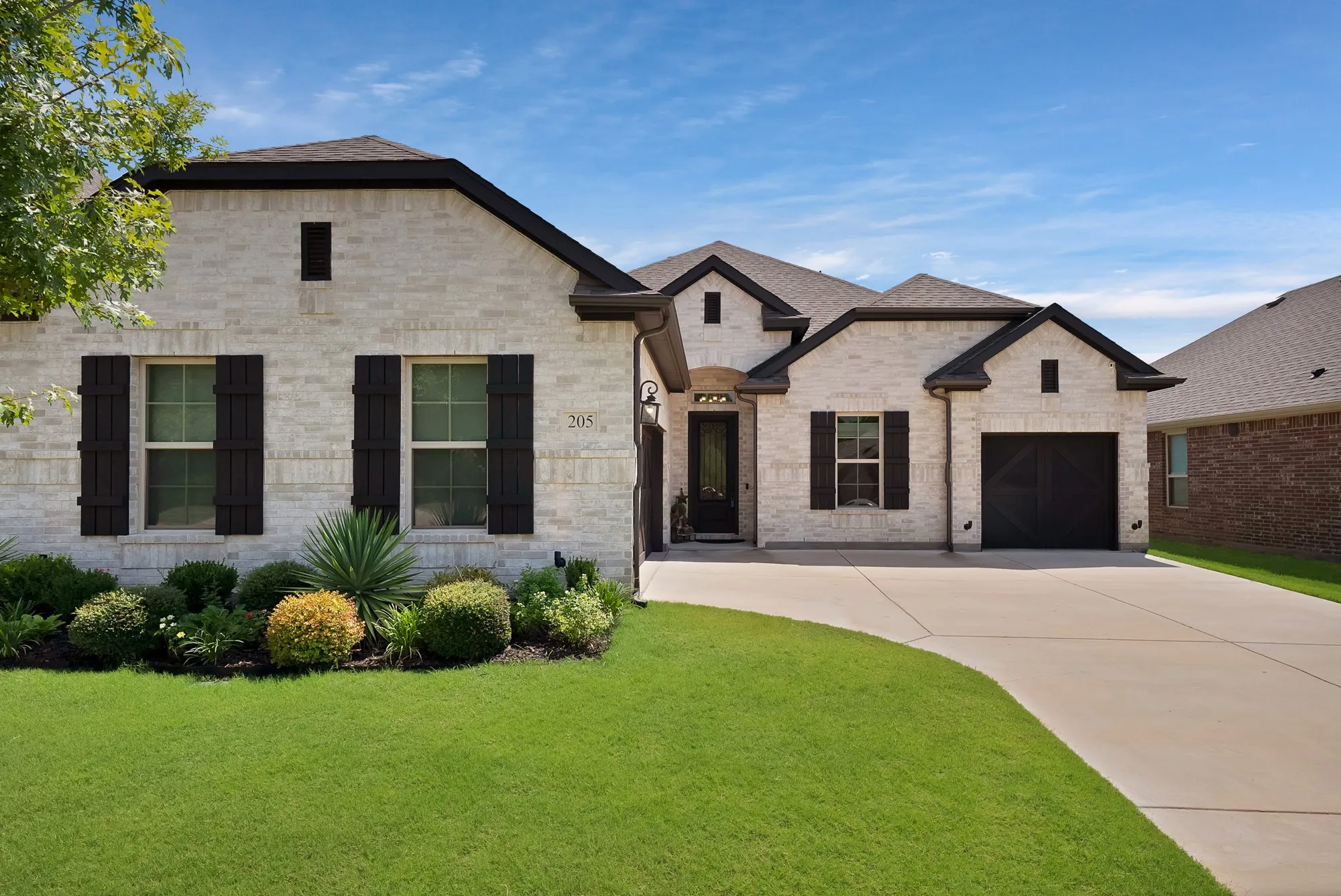 This property features an inviting exterior with light-colored brick, dark shutters, and a well-maintained​​‌​​​​‌​​‌‌​‌‌​​​‌‌​‌​‌​‌​​​‌​​ lawn