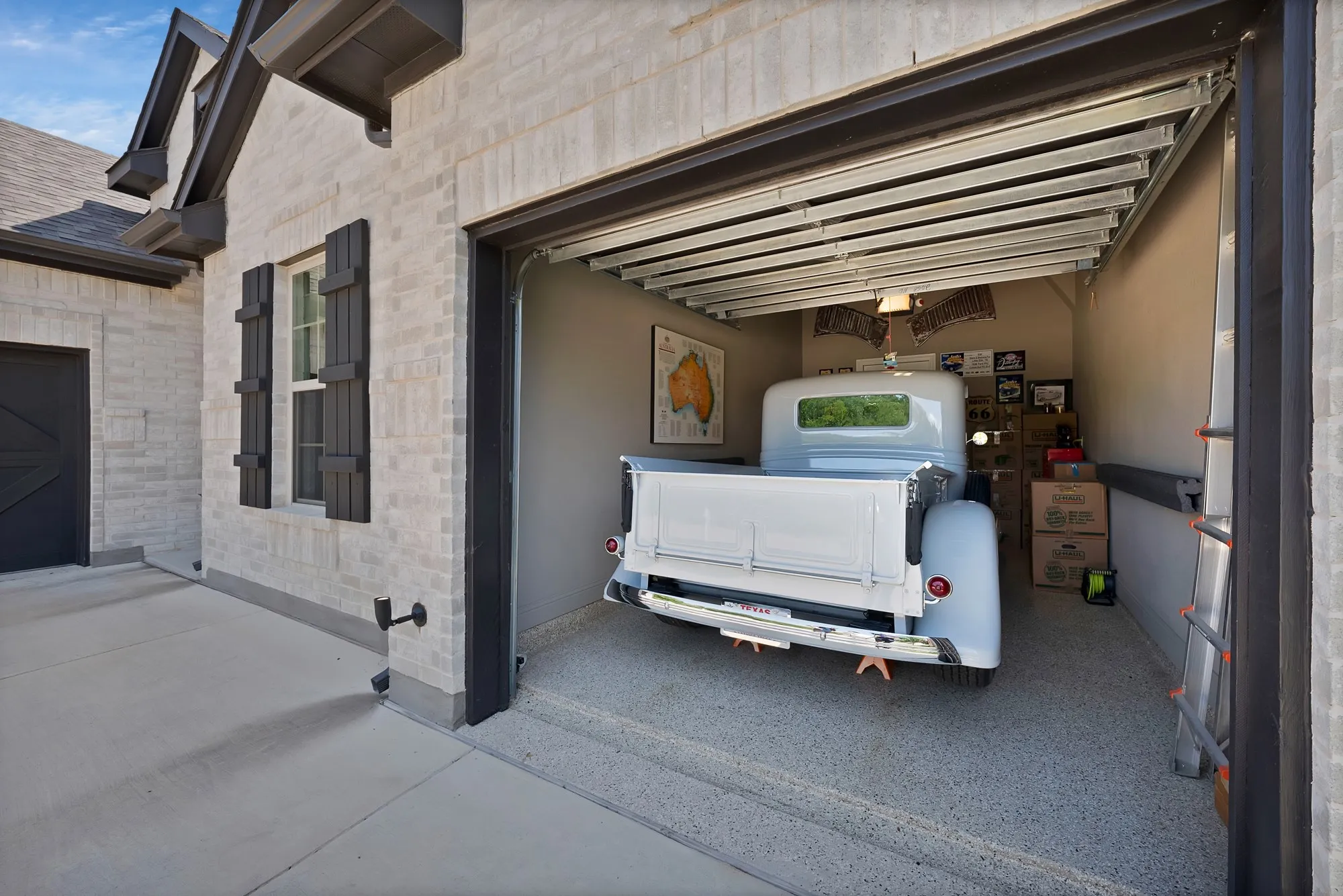 The property features a garage with an open door revealing an interior space with a light-colored floor