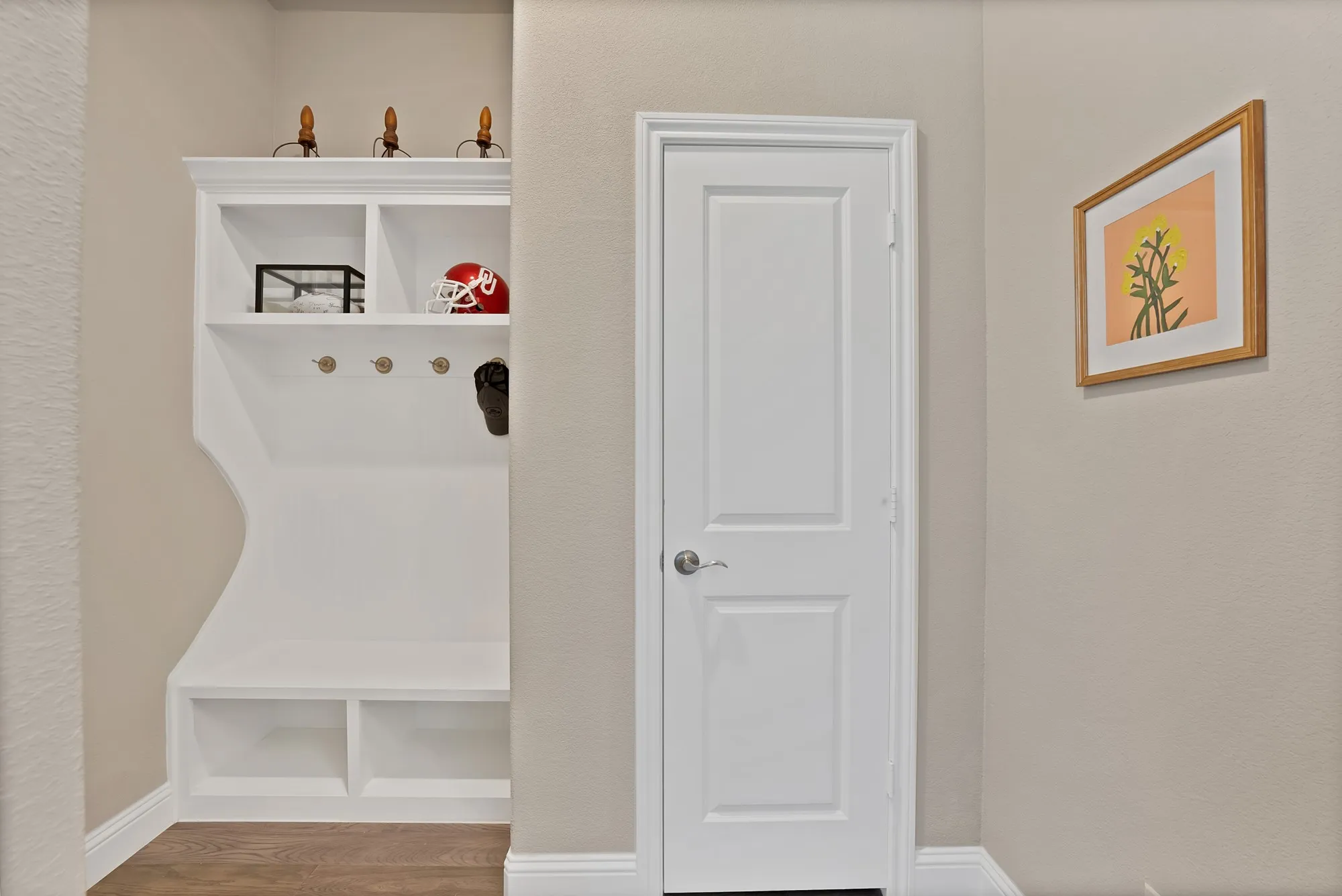 The property features a built-in white mudroom bench with storage cubbies, shelving, and coat hooks