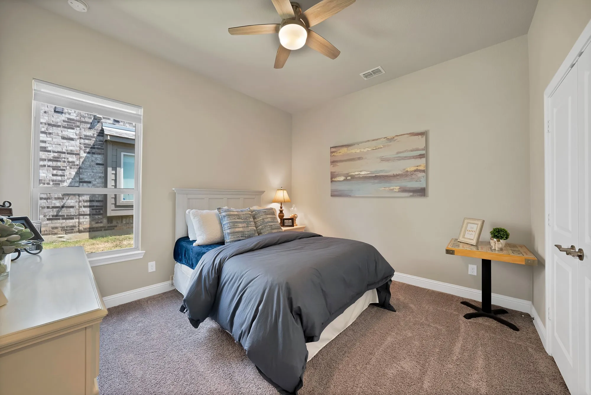 This room features a ceiling fan with integrated lighting, a window providing natural light, and carpeting