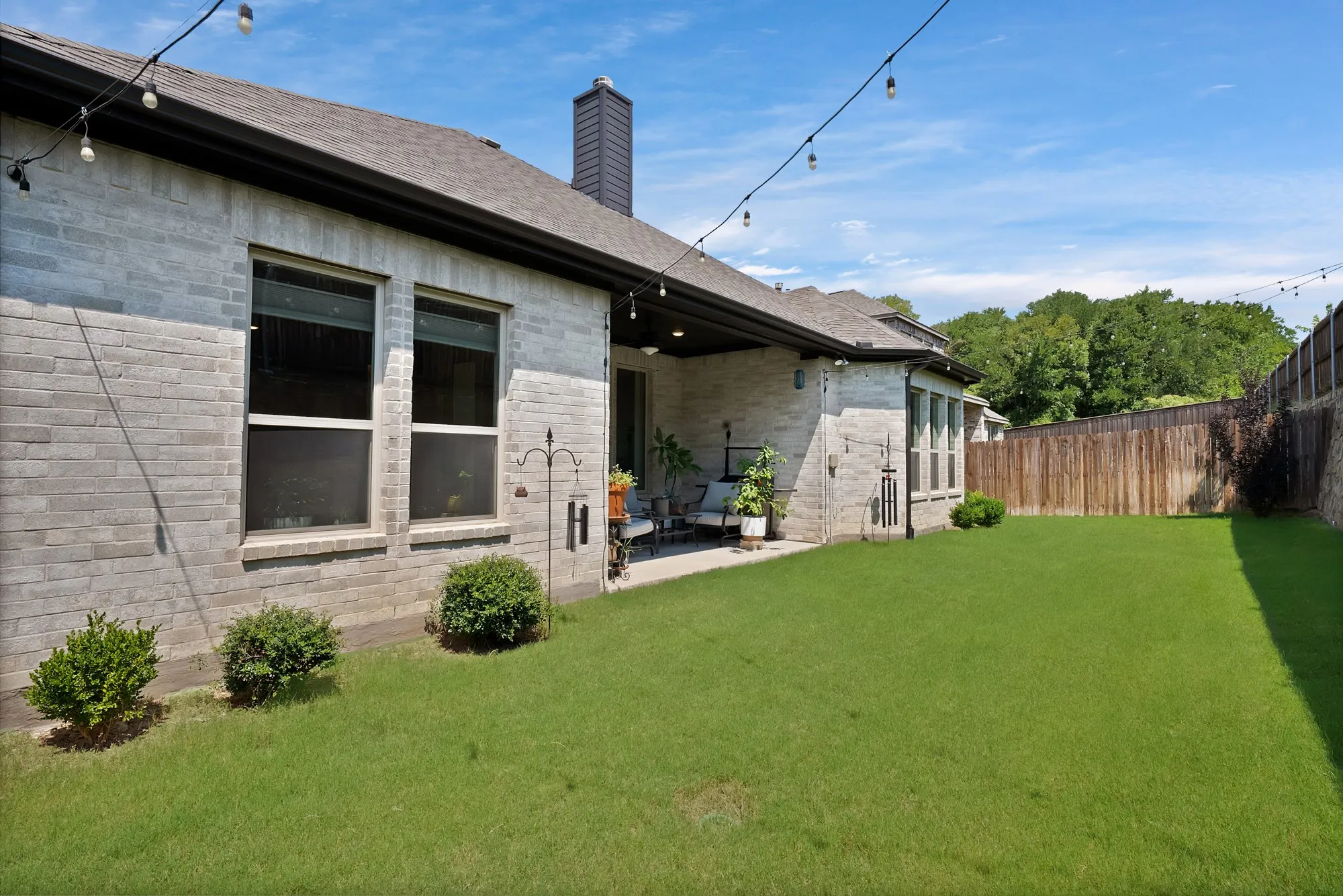 The property features an extensive backyard with a well-maintained lawn and a covered patio area