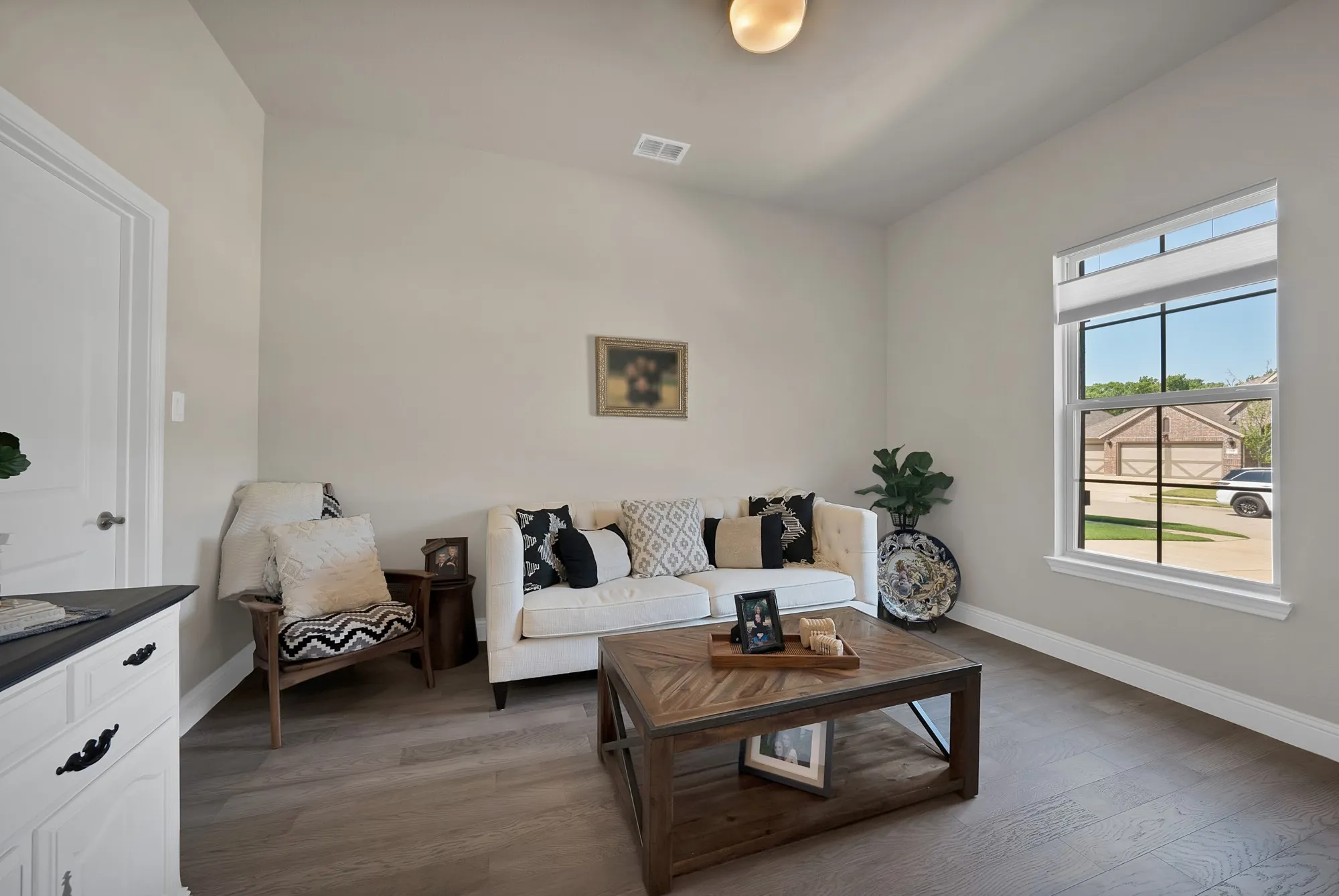 The living space features light-colored walls, a prominent window, and hard surface flooring