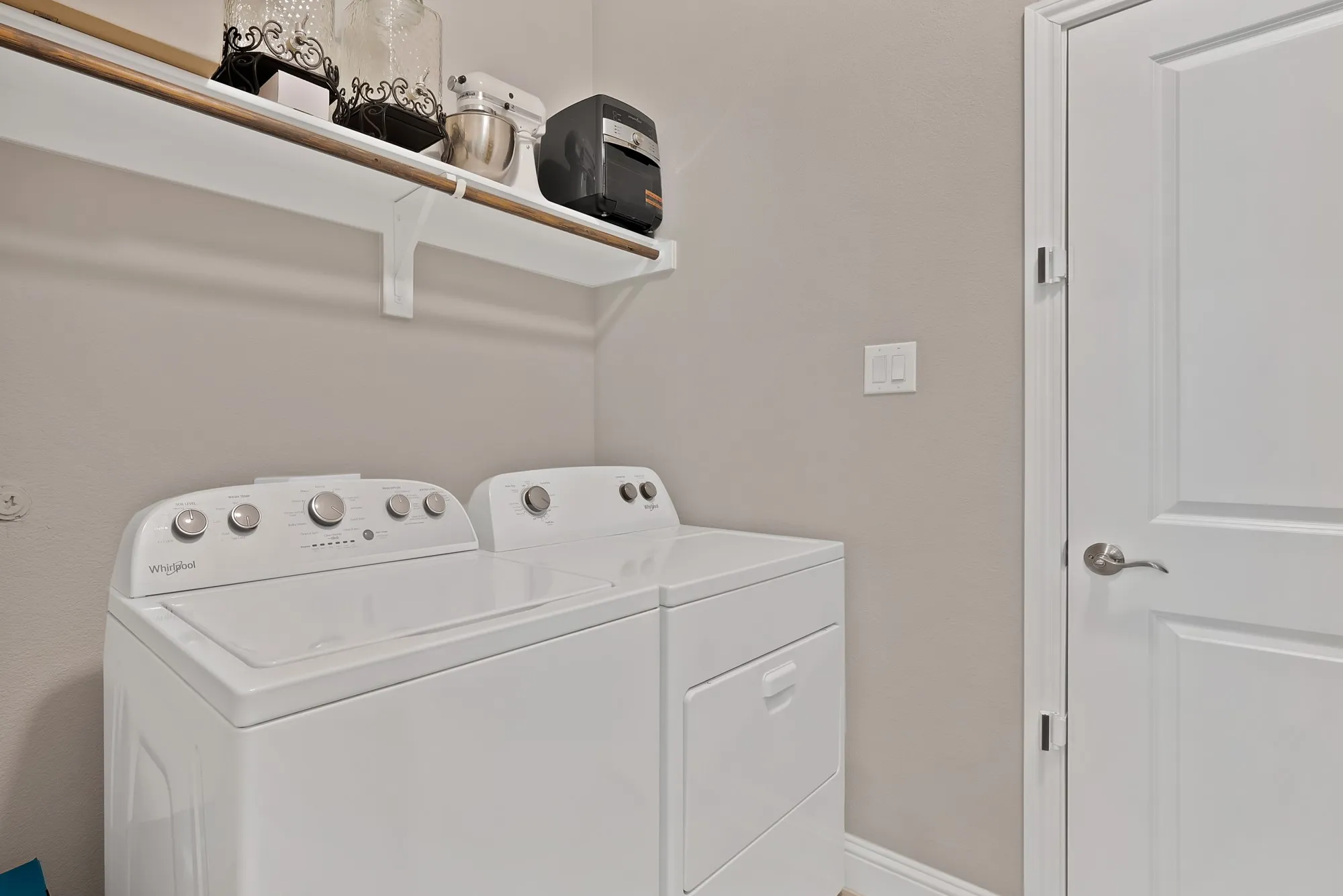 The property features a dedicated laundry area with a white top-loading washing machine and a white front-loading dryer
