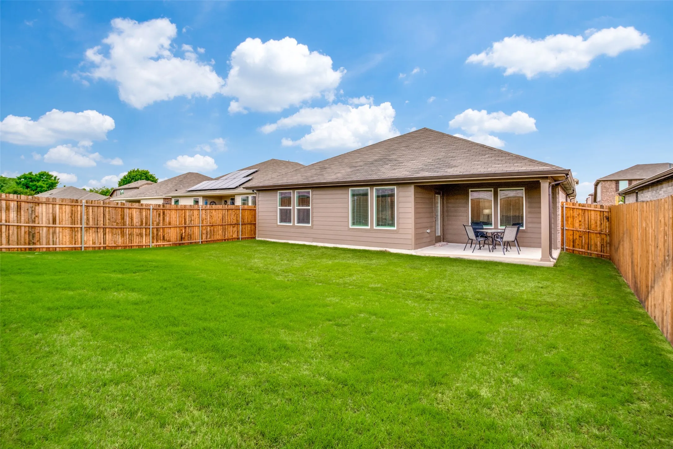 Expansive grassy yard area with a wood privacy fence