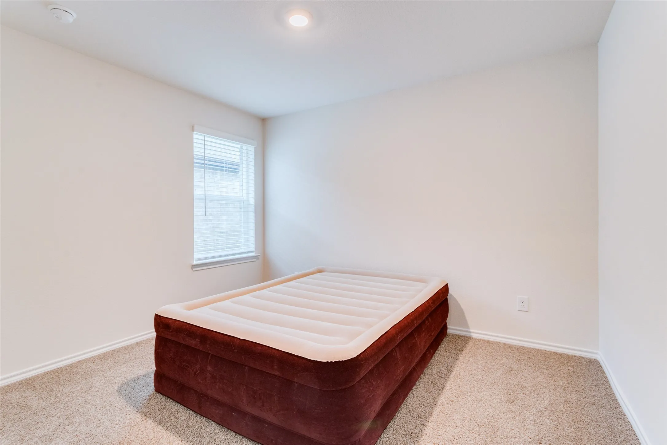 Carpeted room featuring a single window with blinds, recessed ceiling light, and baseboard molding