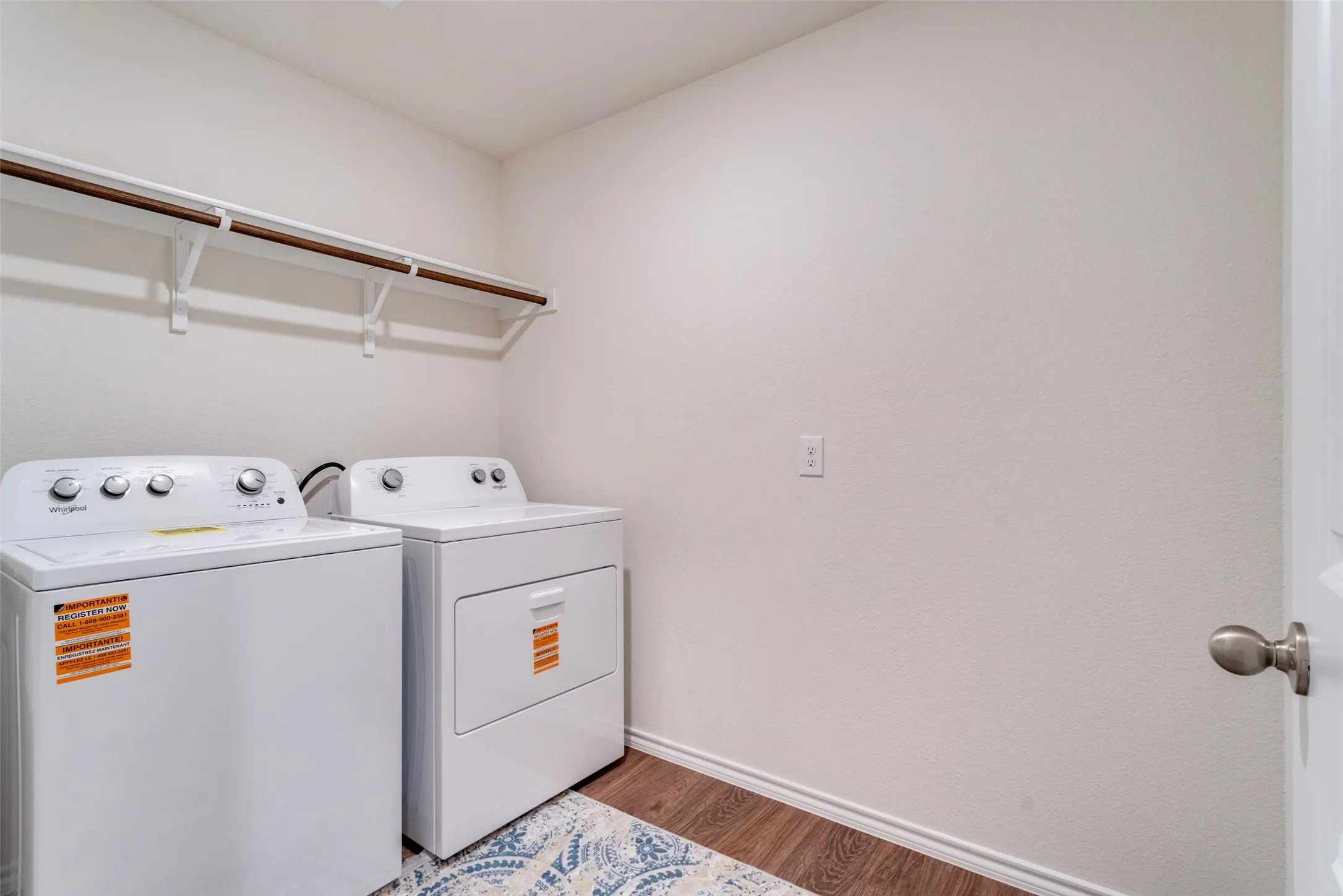 Dedicated laundry area featuring wood-finish flooring