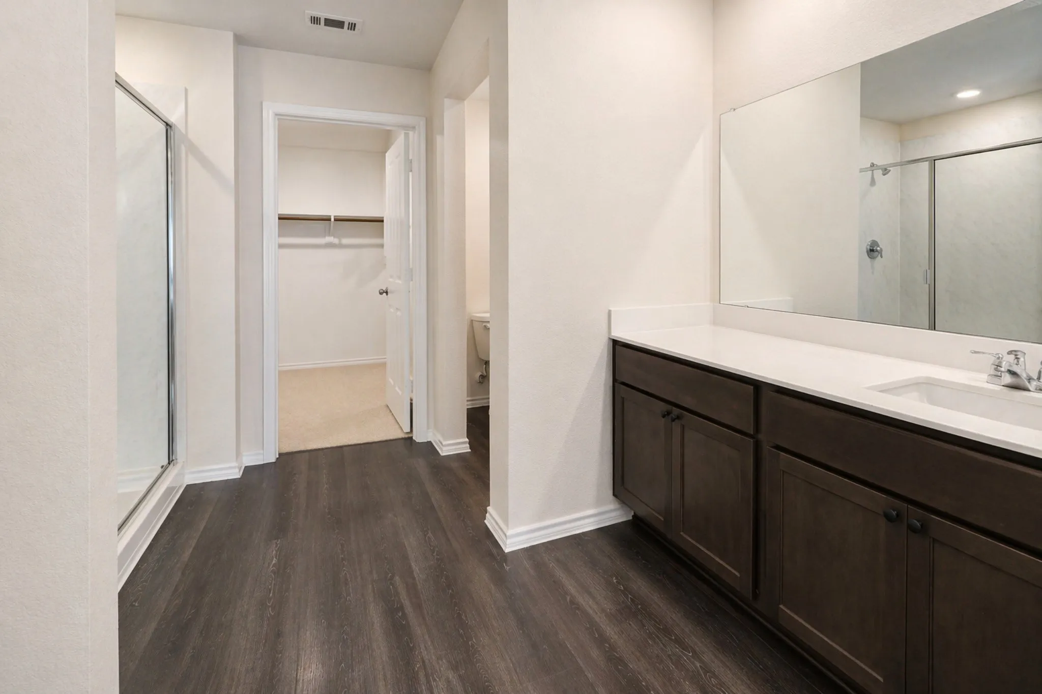 Bathroom featuring a dark wood-finish vanity with a light-toned countertop and an integrated sink