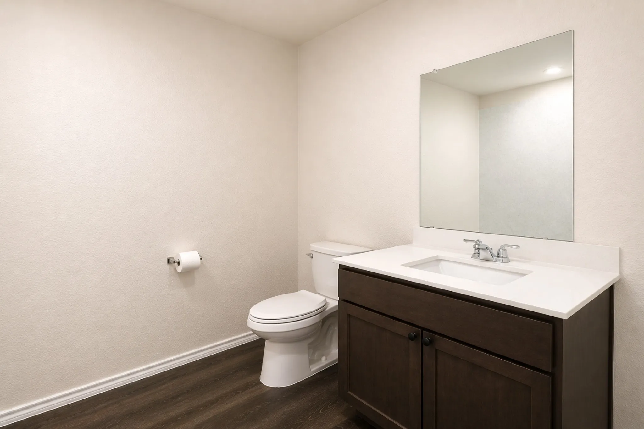 Bathroom featuring a dark wood-finish vanity with a white countertop, an undermount sink, and a chrome faucet