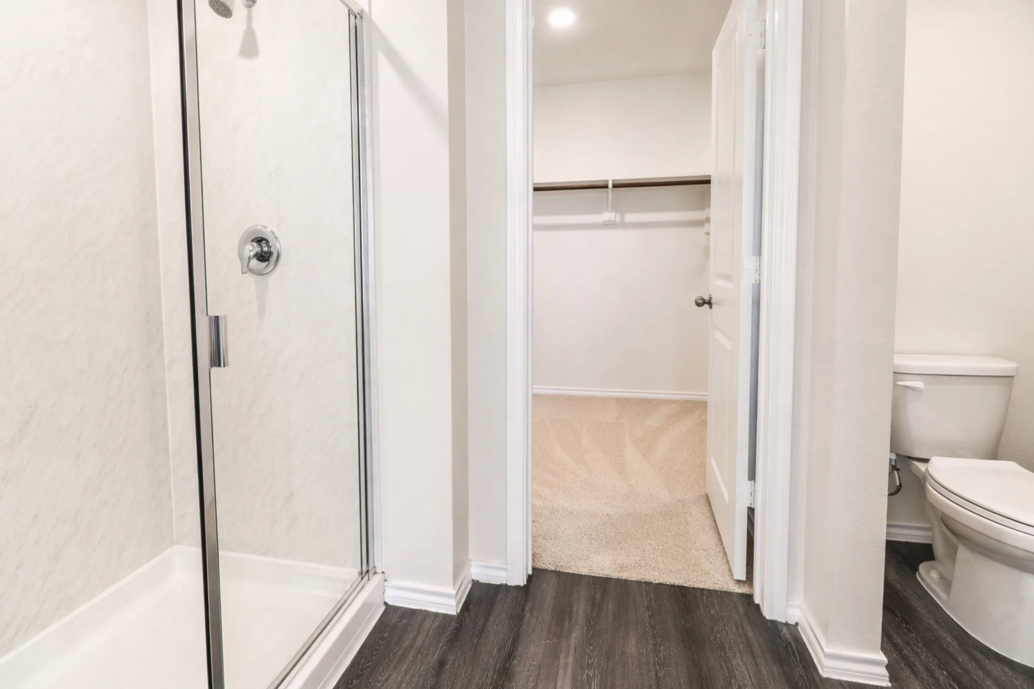 Walk-in shower with clear glass enclosure and chrome fixtures