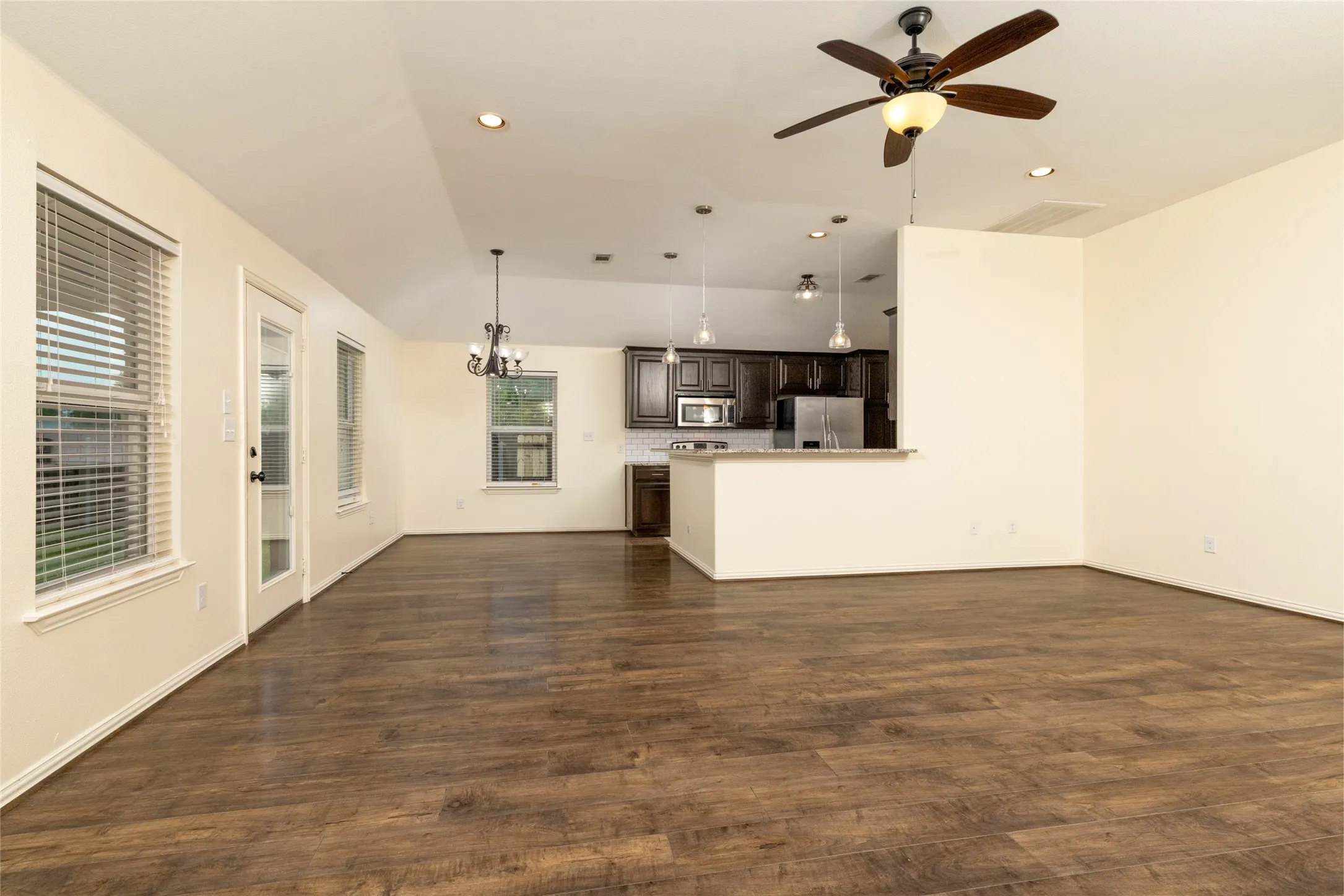 Spacious room with wood-finish flooring, recessed lighting, and a ceiling fan