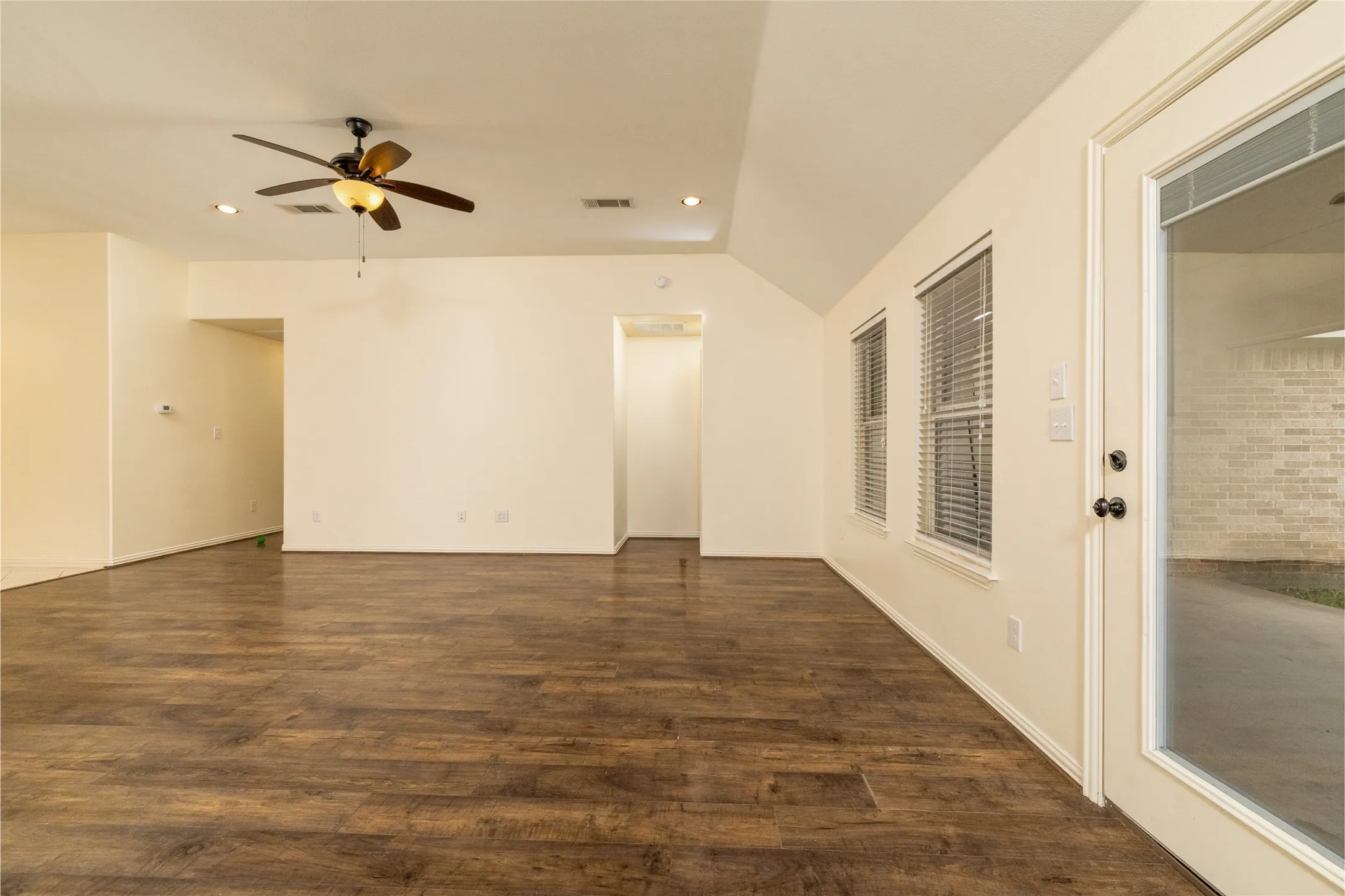 Spacious room featuring wood-finish flooring, recessed lighting, and a ceiling fan
