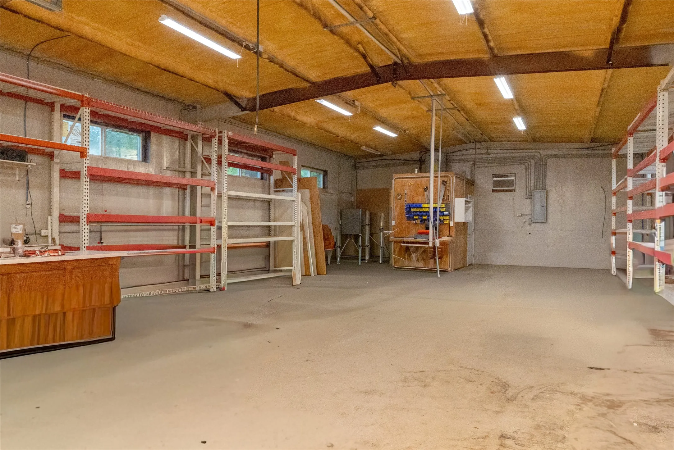 Spacious interior with concrete flooring and exposed ceiling beams