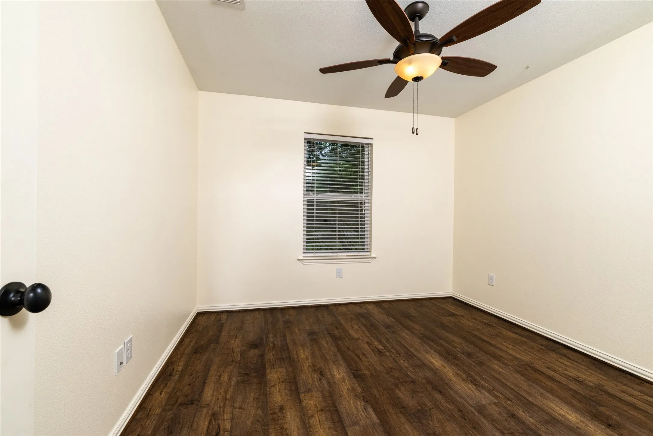 Room featuring wood-finish flooring, a window with blinds, a ceiling fan with integrated lighting, and neutral wall paint