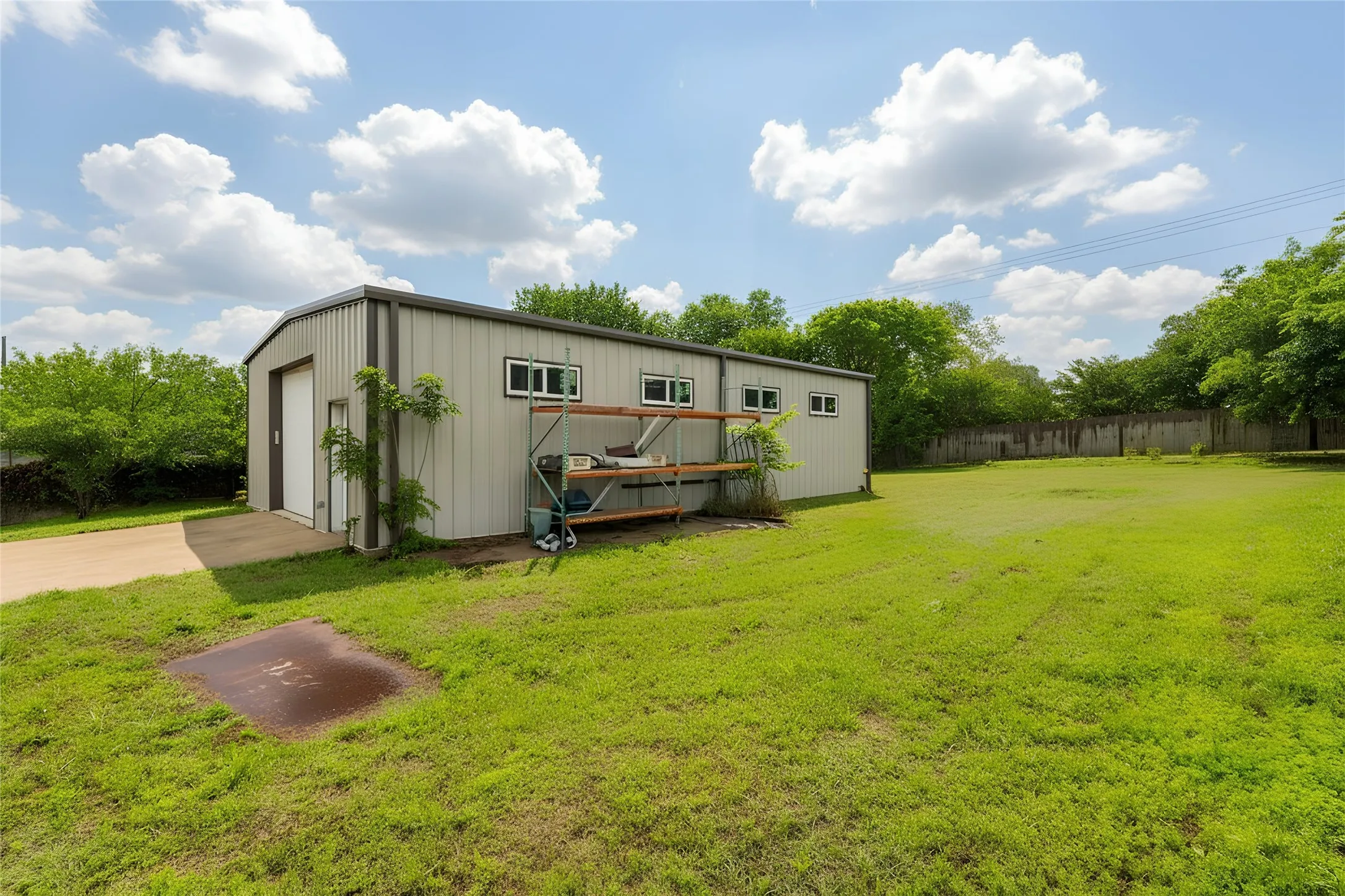 Metal-sided structure featuring a large garage door and multiple windows