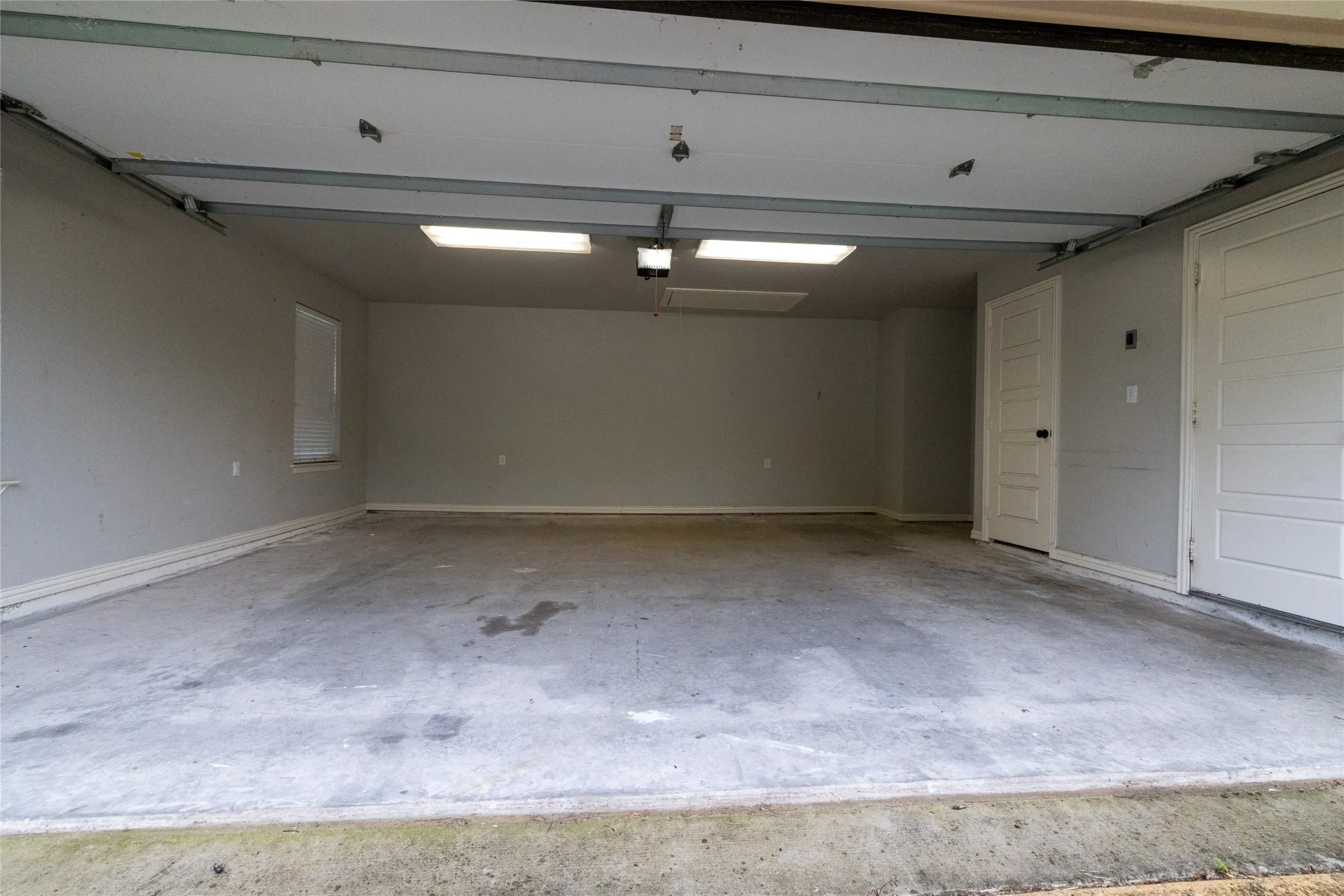 Spacious garage featuring concrete flooring and neutral-toned walls