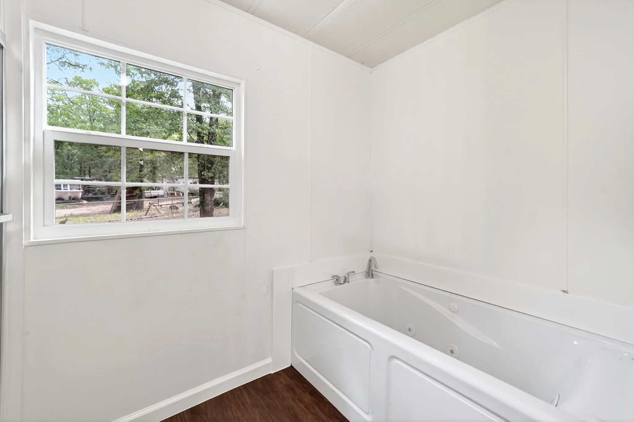 White jetted tub with wall-mounted​​‌​​​​‌​​‌‌​‌‌​​​‌‌​‌​‌​‌​​​‌​​ fixtures