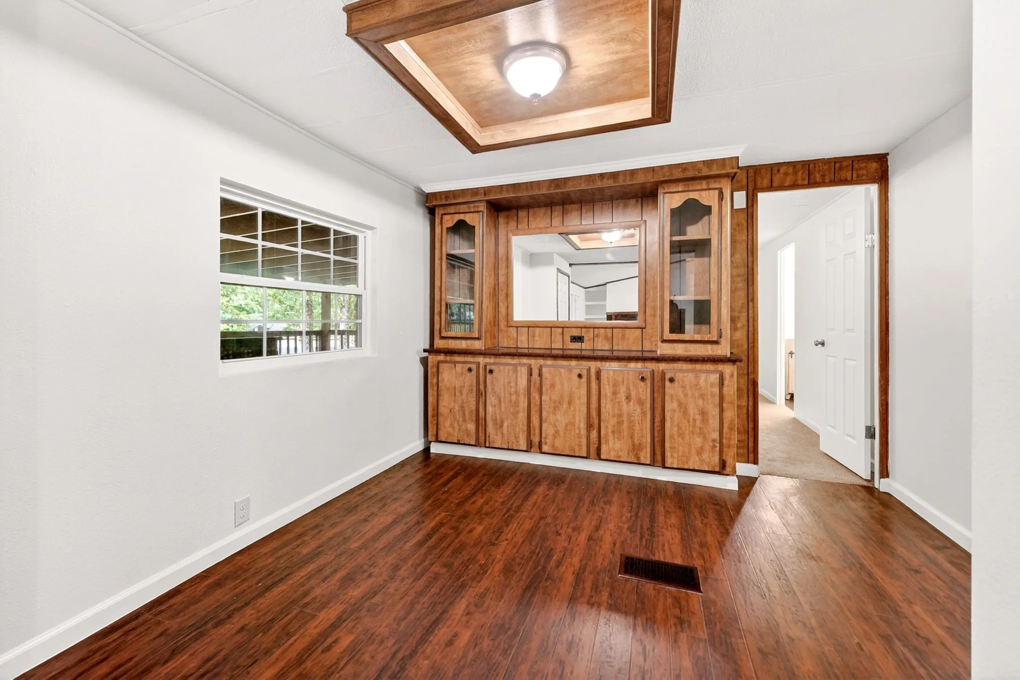Built-in wood cabinetry with glass-front display cabinets and integrated mirror