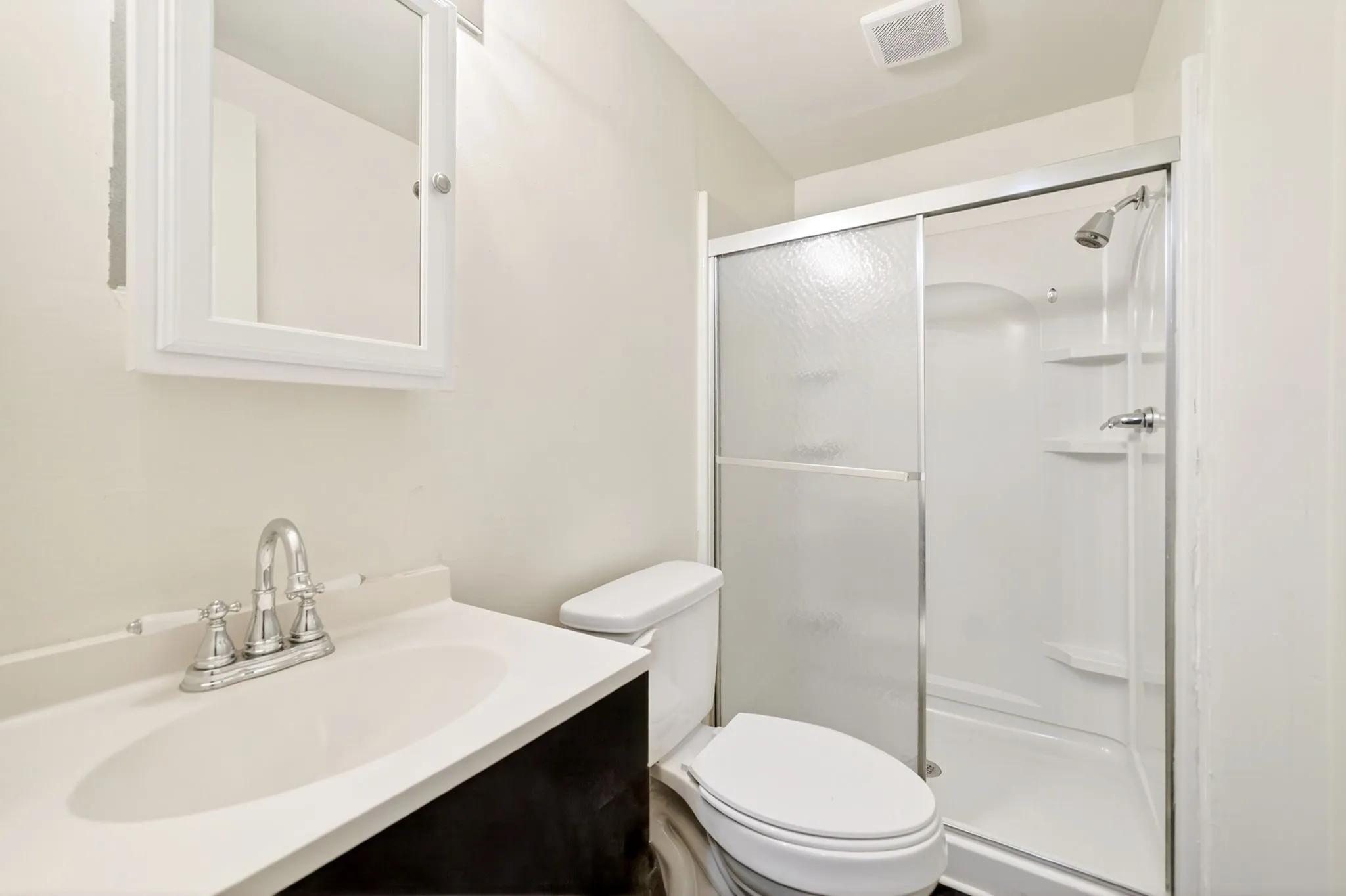 Bathroom featuring a vanity with an integrated sink, a chrome faucet, and a wall-mounted medicine cabinet