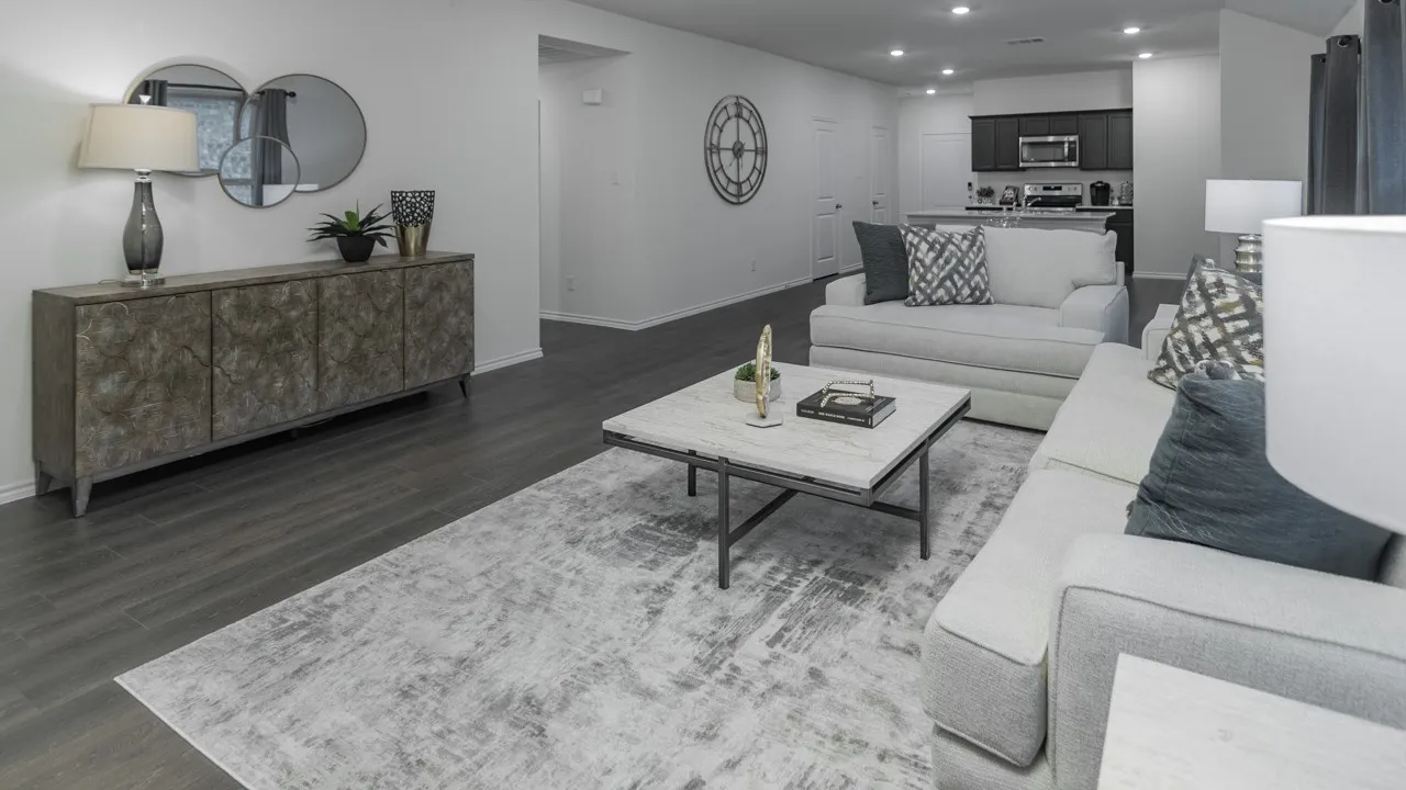 Open-concept living space featuring wood-finish flooring, recessed lighting, and a kitchen with dark cabinetry and stainless steel appliances