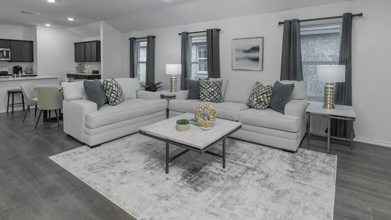Open-concept living area featuring wood-finish flooring, a kitchen bar with seating, and a vaulted ceiling