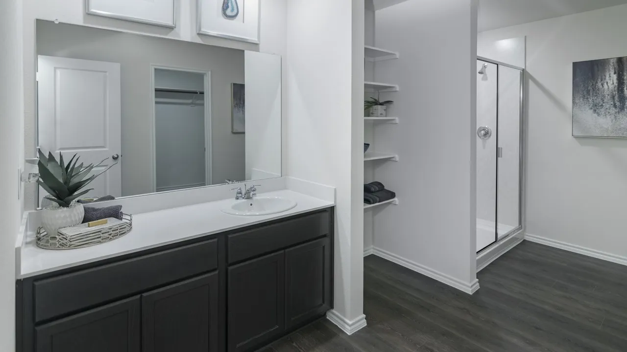 Bathroom featuring a single vanity with a white countertop and dark cabinetry