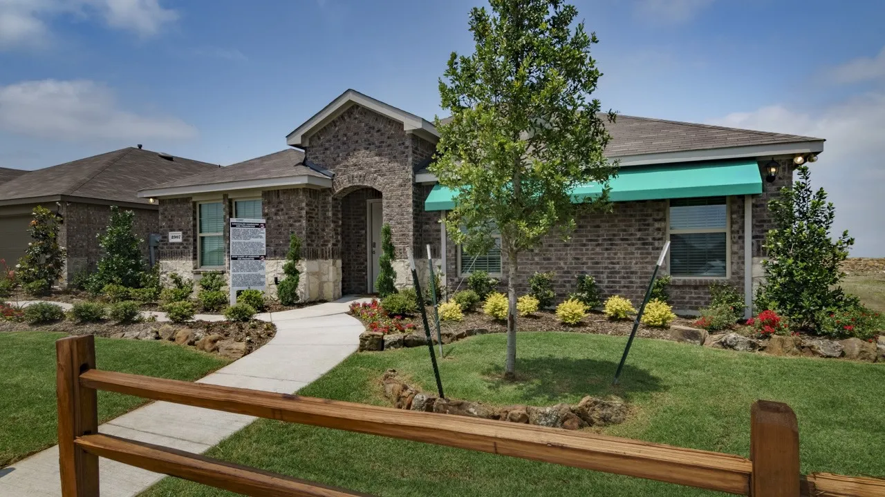 Brick exterior with stone accents, covered entry, and a manicured lawn