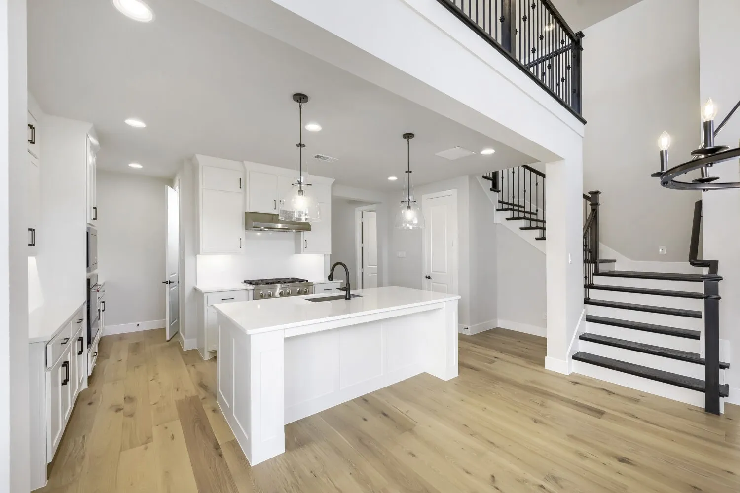 Open-concept kitchen and living area featuring a central island with countertop seating, stainless steel appliances, and recessed lighting