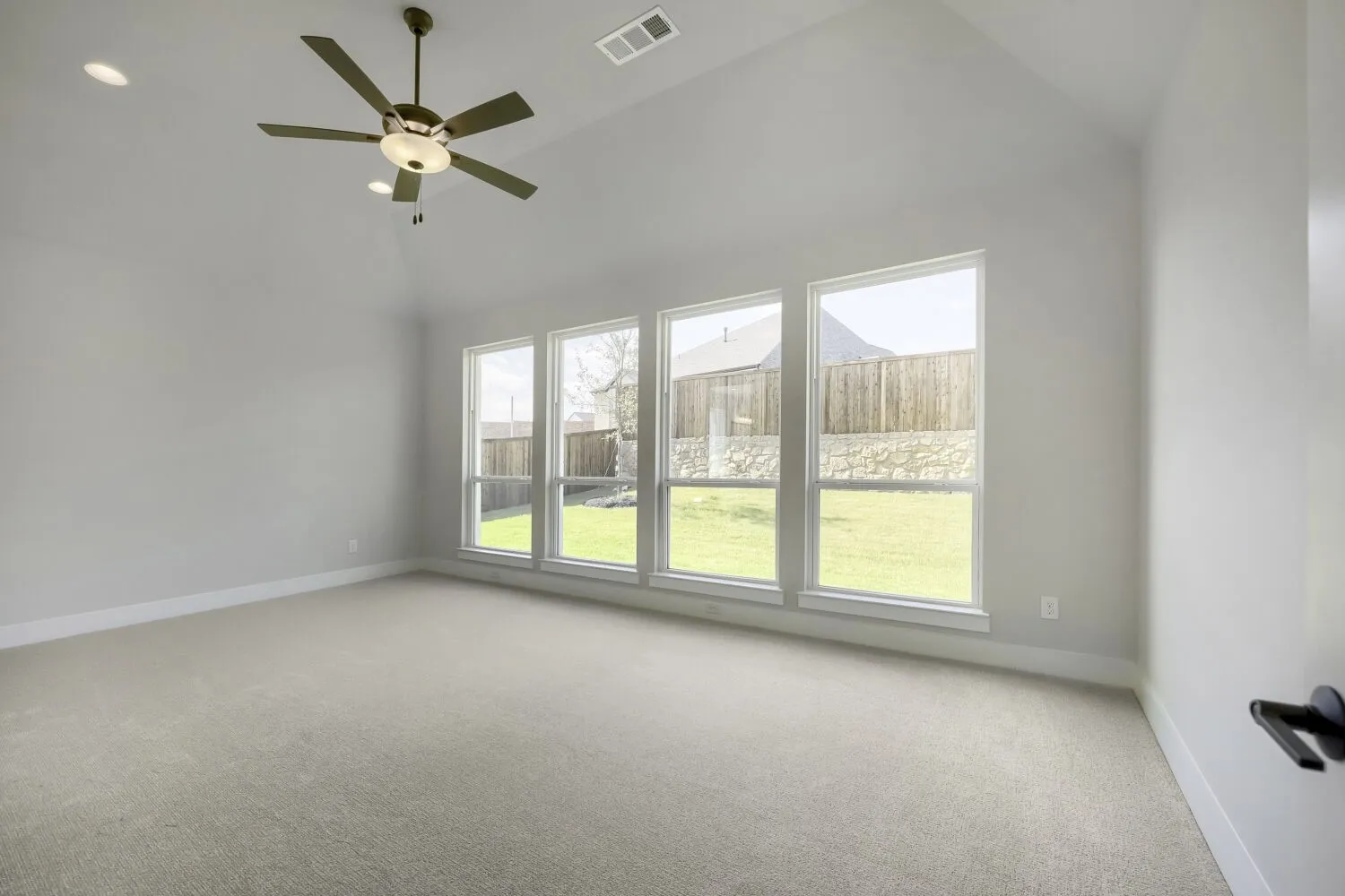 Room featuring a vaulted ceiling with a ceiling fan, recessed lighting, and light-colored carpeting