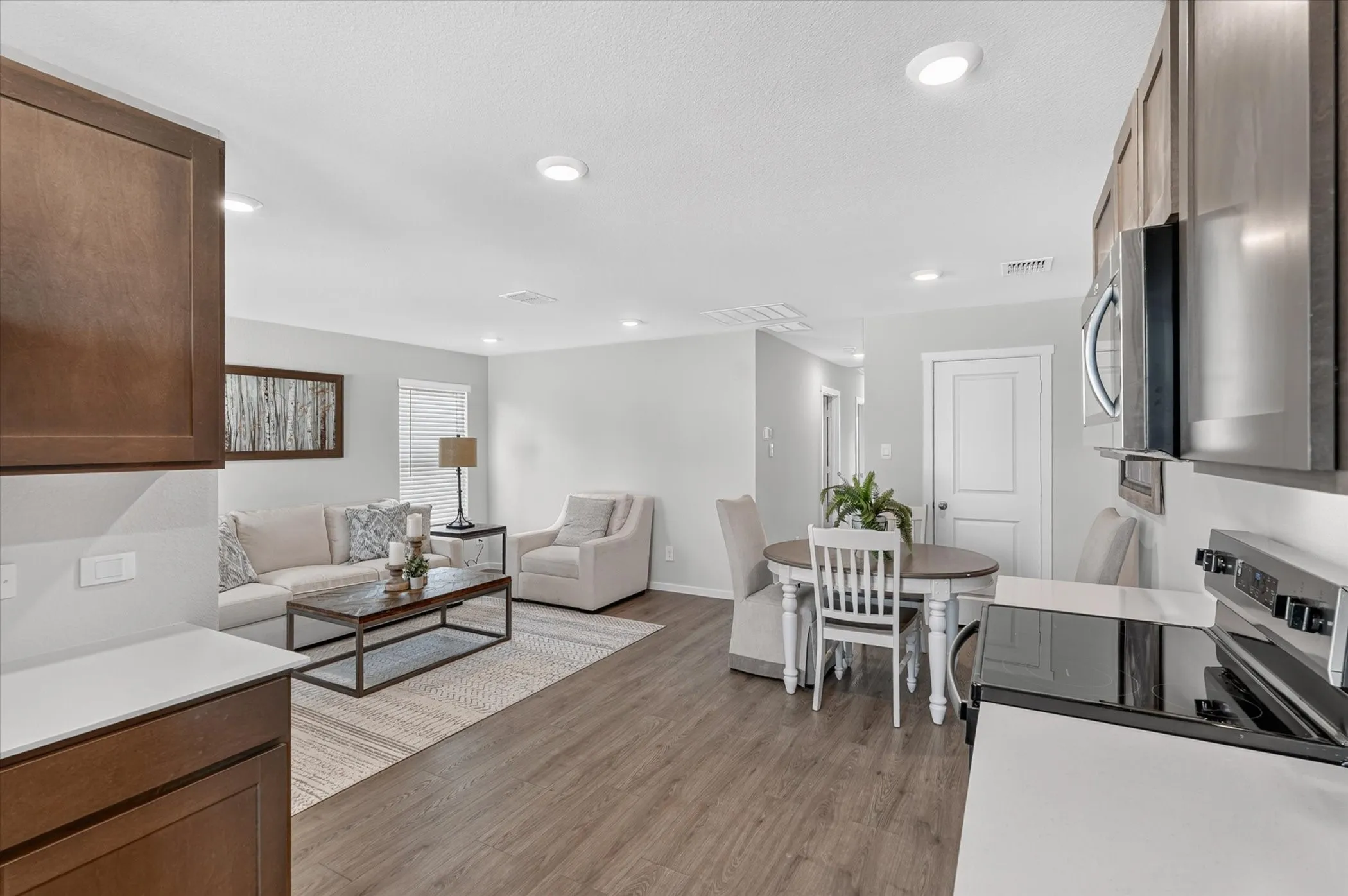 Open-concept living space featuring wood-finish flooring, recessed lighting, and light gray wall tones
