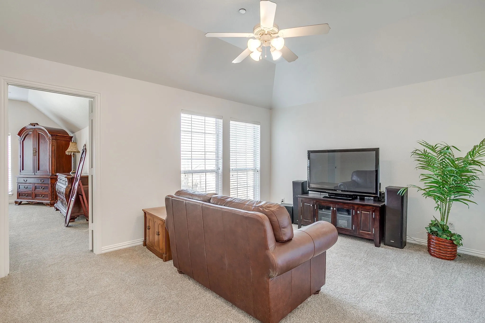 Living room with lofted ceiling, light carpet, and ceiling fan