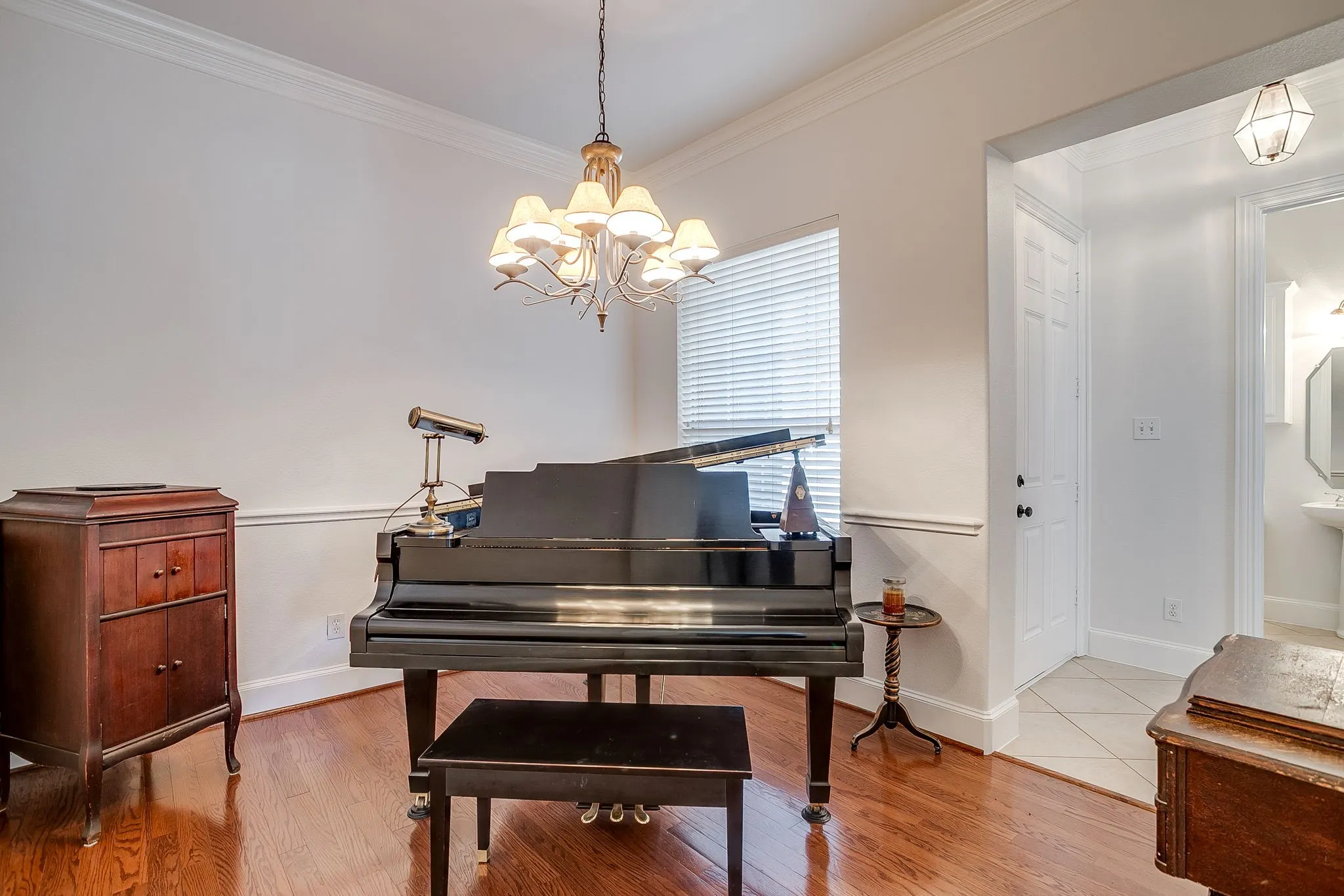 Formal dining/office/sitting room featuring crown molding, a chandelier, and wood finished floors