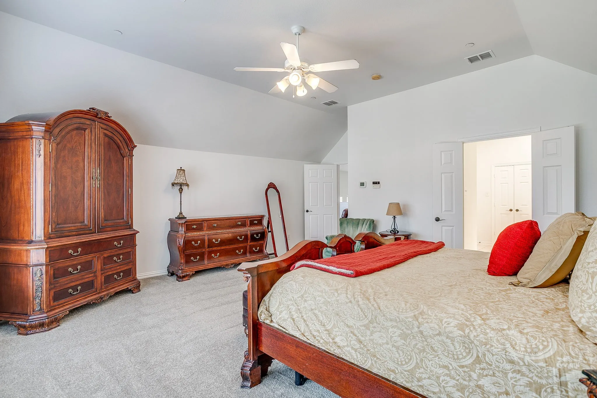 Bedroom featuring lofted ceiling, light colored carpet, and a ceiling fan