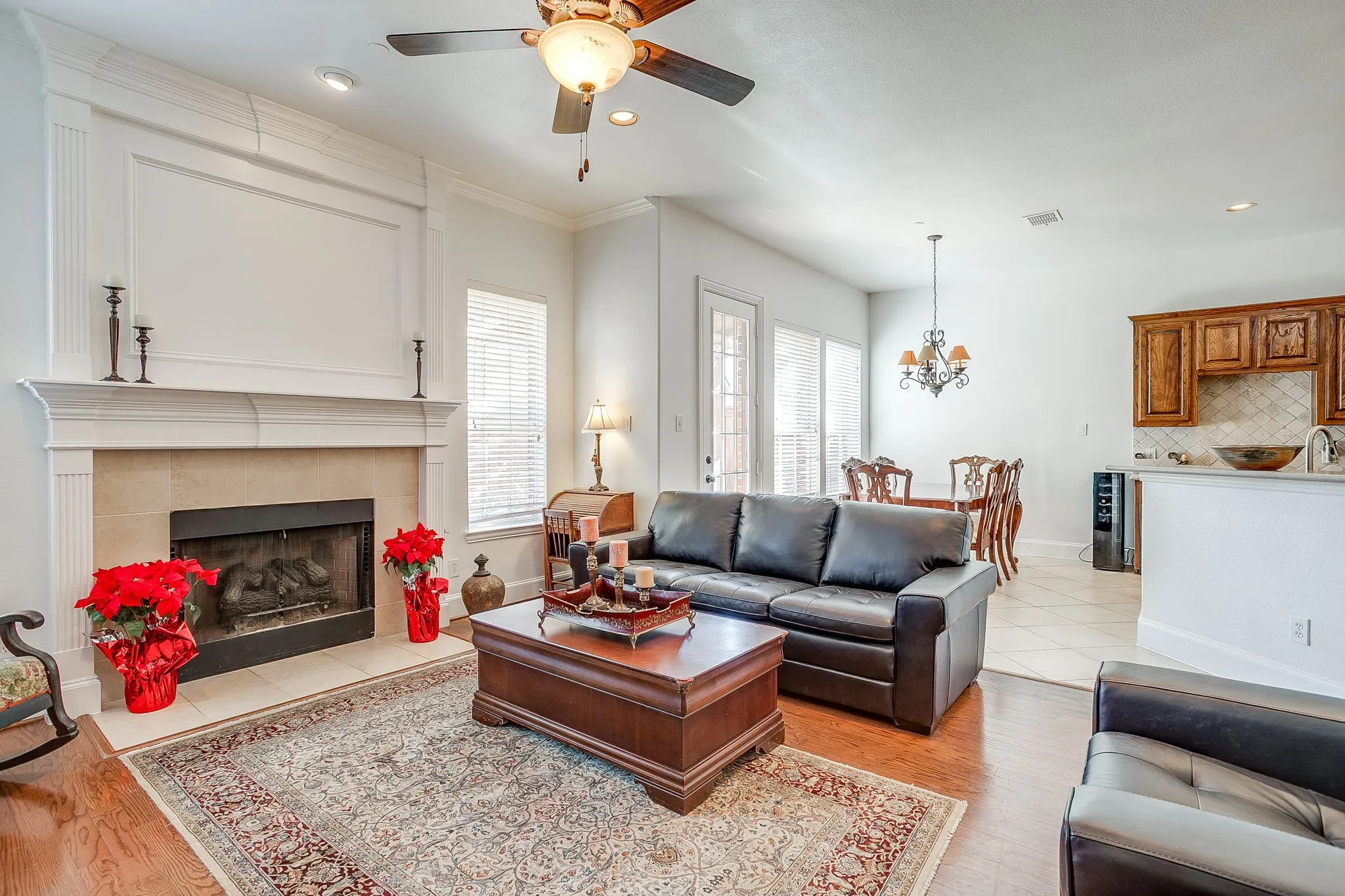 Living room with a tile fireplace, light wood finished floors, recessed lighting, a ceiling fan, and a chandelier