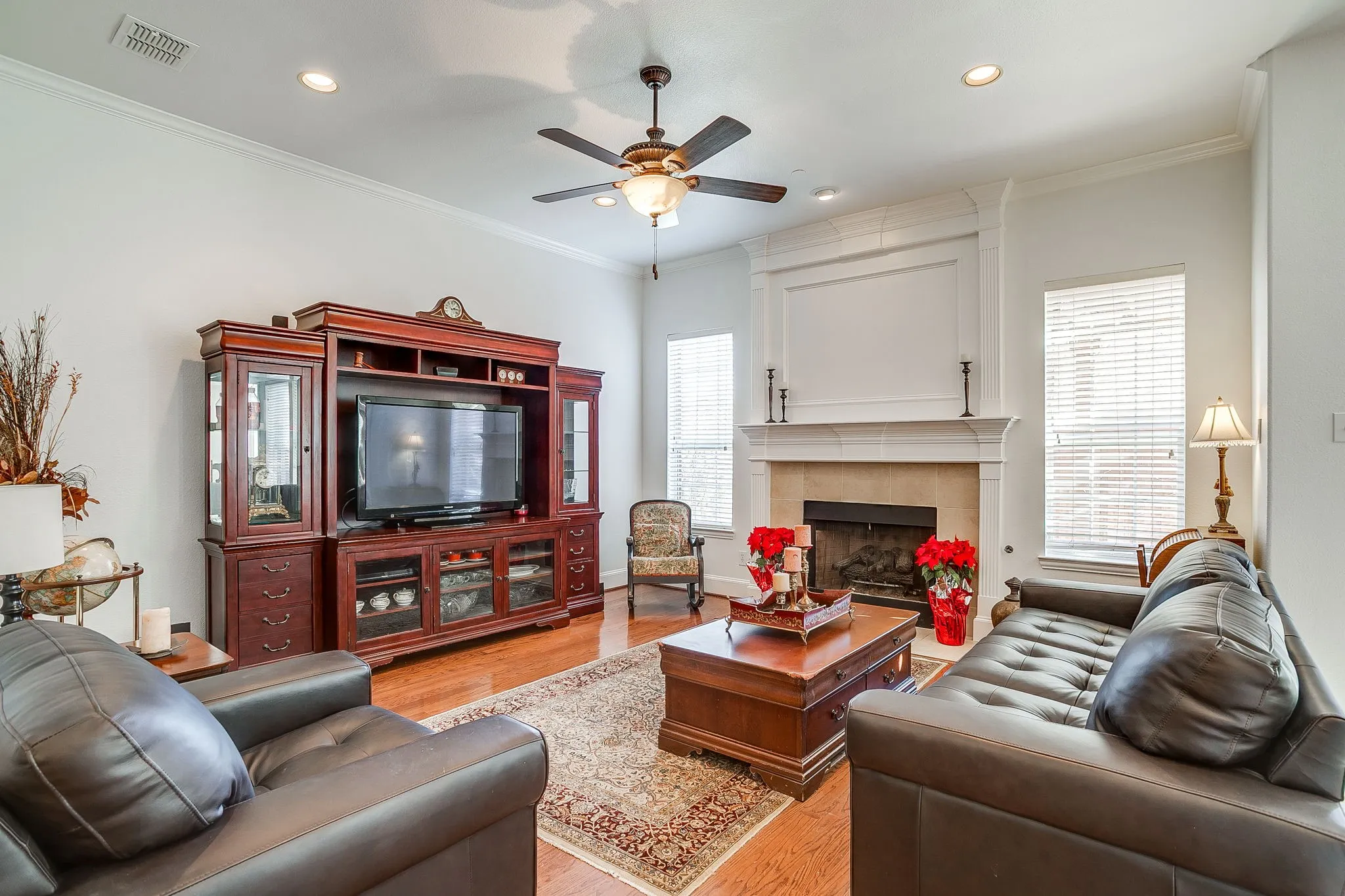 Spacious Living area featuring light wood-style flooring, a tile fireplace, ceiling fan, decorative molding, and recessed lighting.