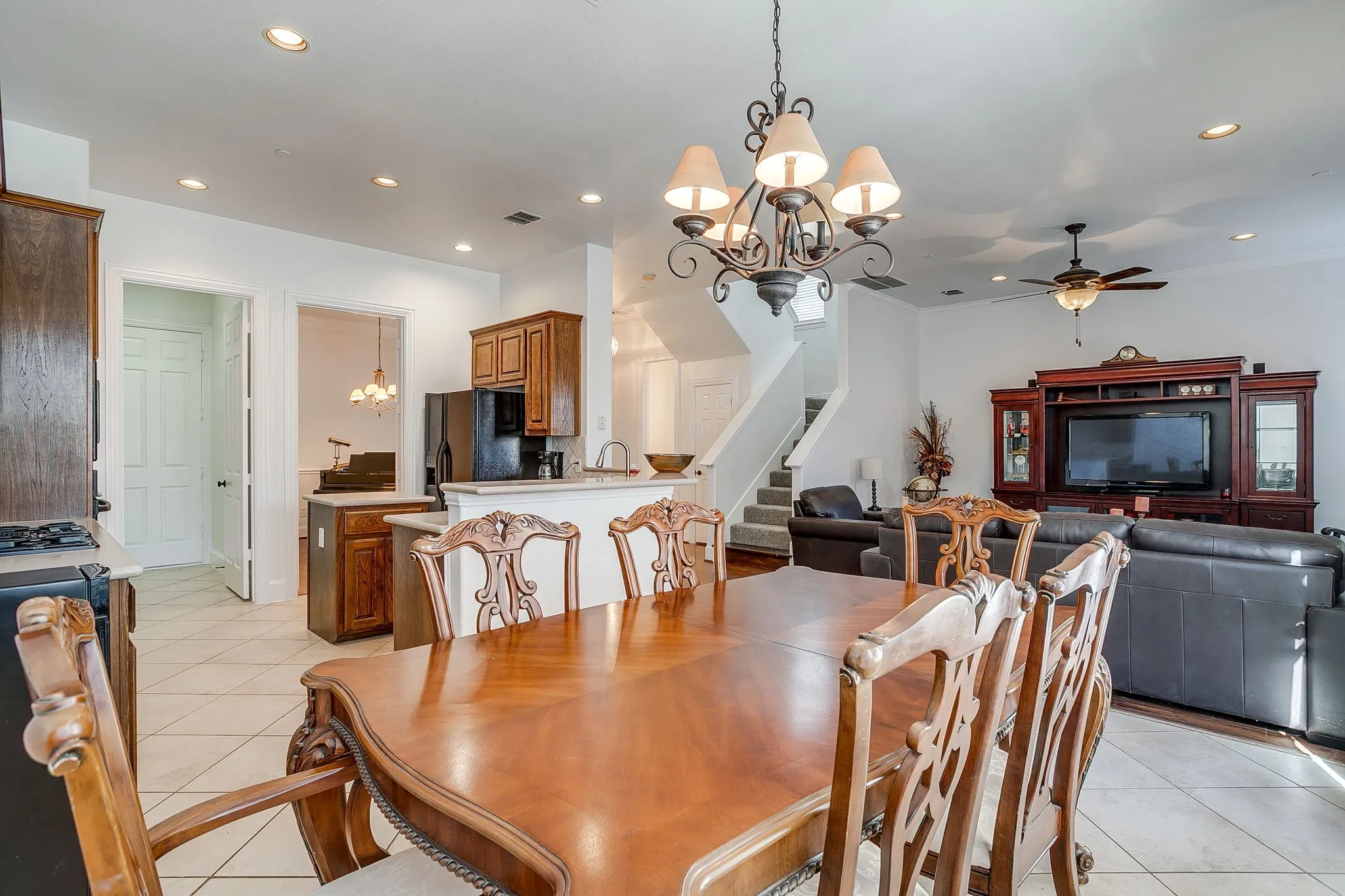Dining room featuring a chandelier, stairs, light tile patterned floors, ceiling fan, and recessed lighting
