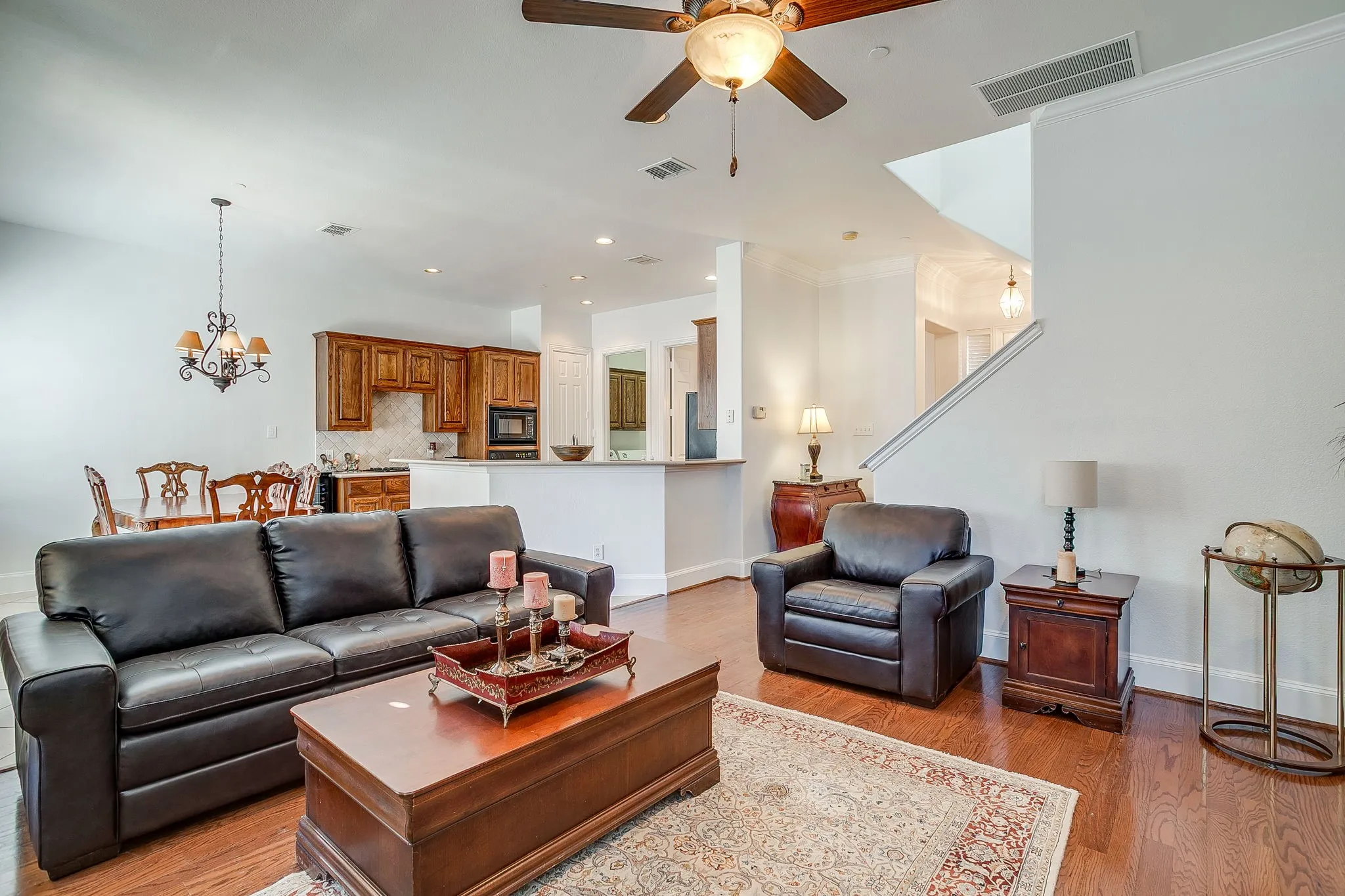Living room with wood finished floors, a chandelier, ceiling fan, and recessed lighting