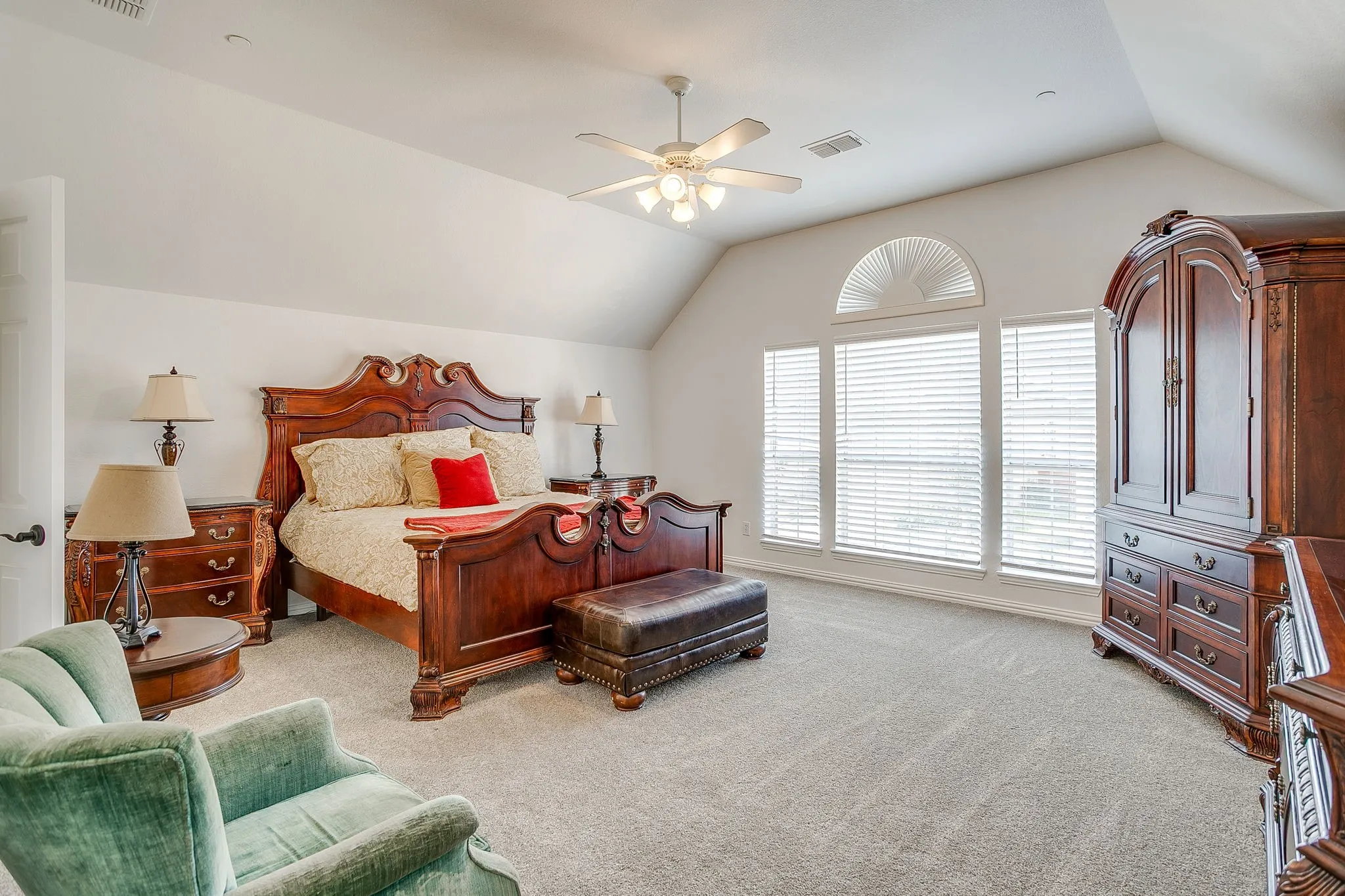 Bedroom with lofted ceiling, light colored carpet, and ceiling fan